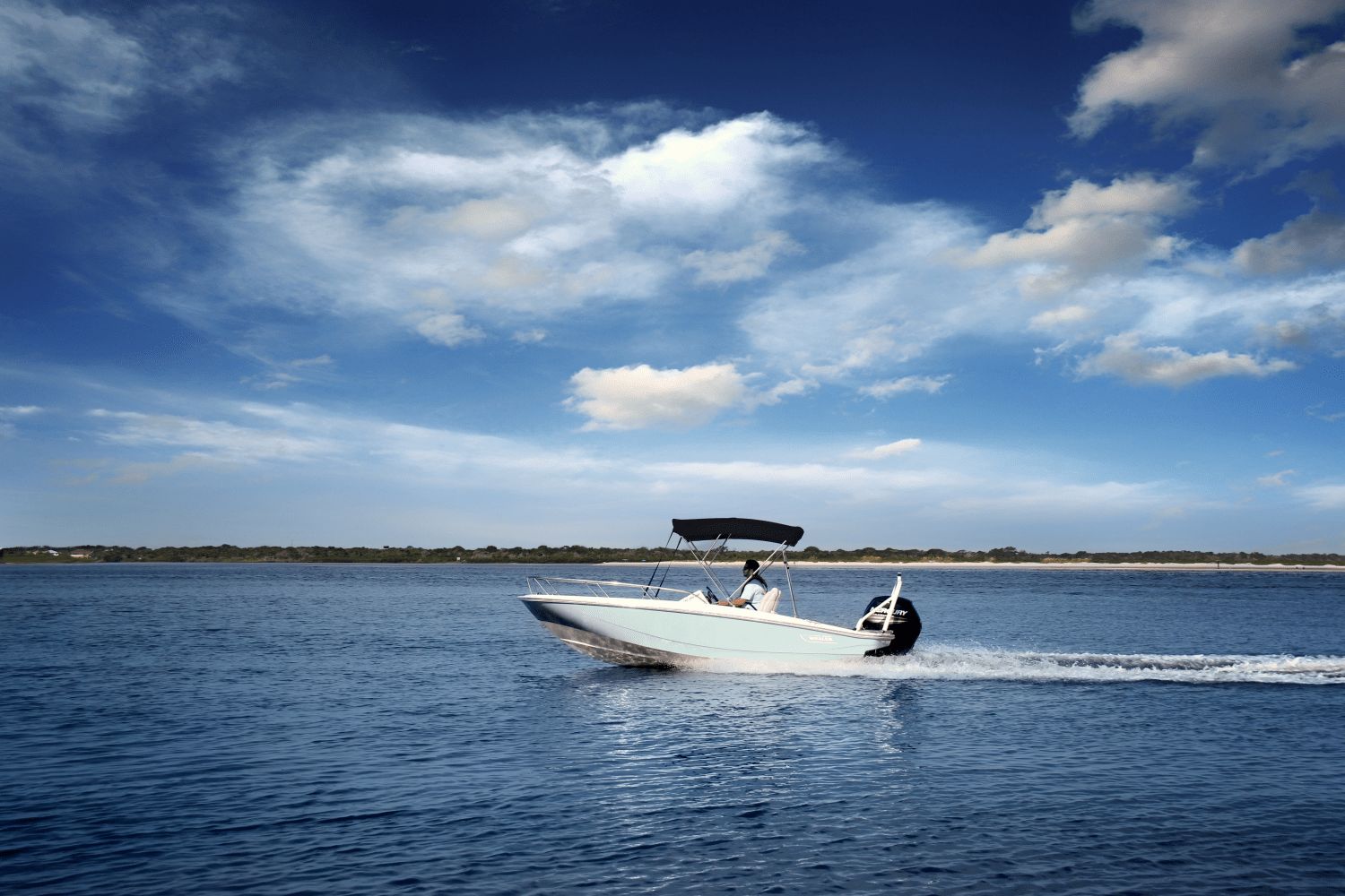 2026 Boston Whaler 160 Super Sport on calm water under a blue sky.