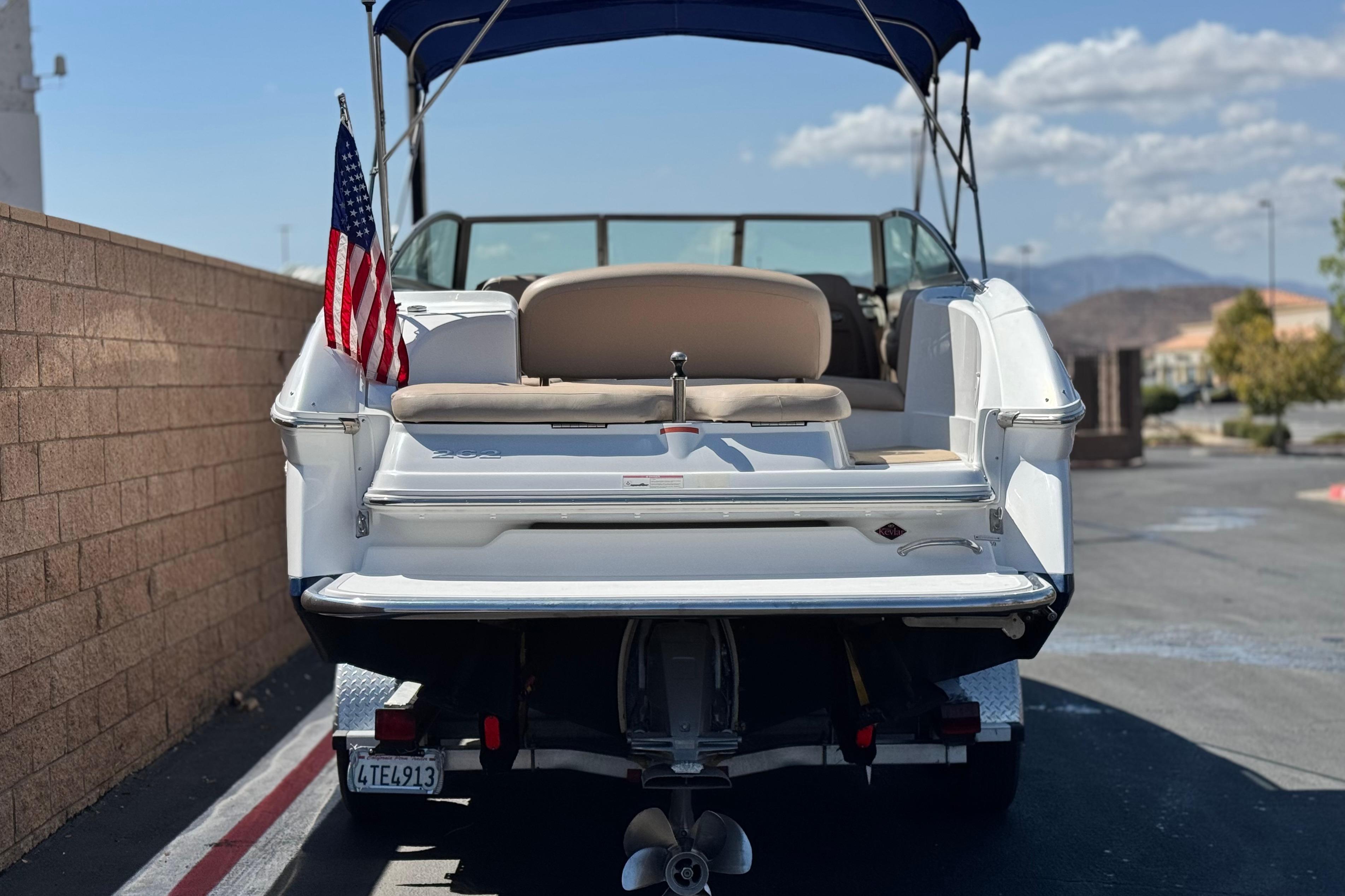 2008 Cobalt 262 boat with American flag, parked on a sunny day.