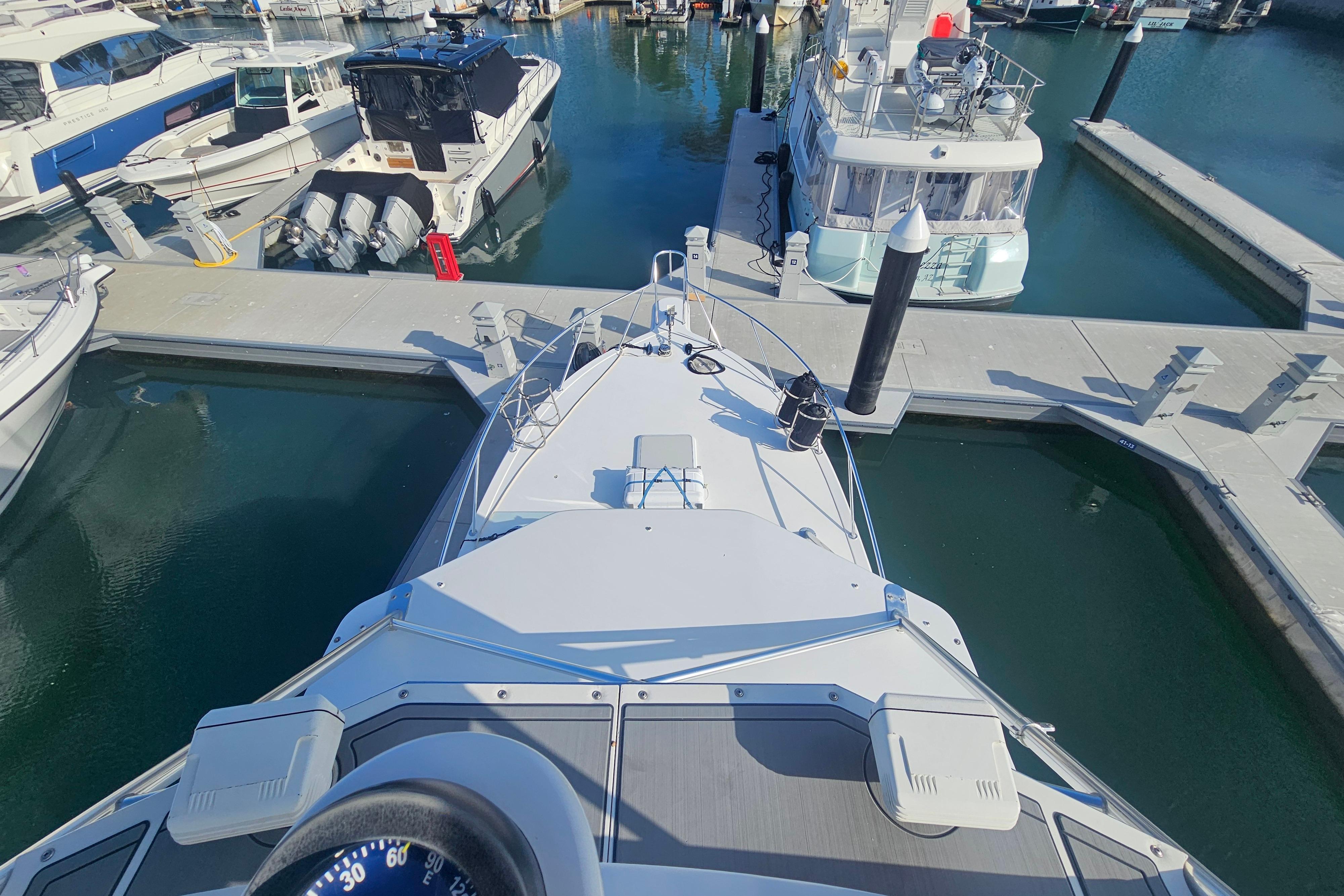 Bow view of a 2003 Topaz 32 Express yacht docked in a marina.