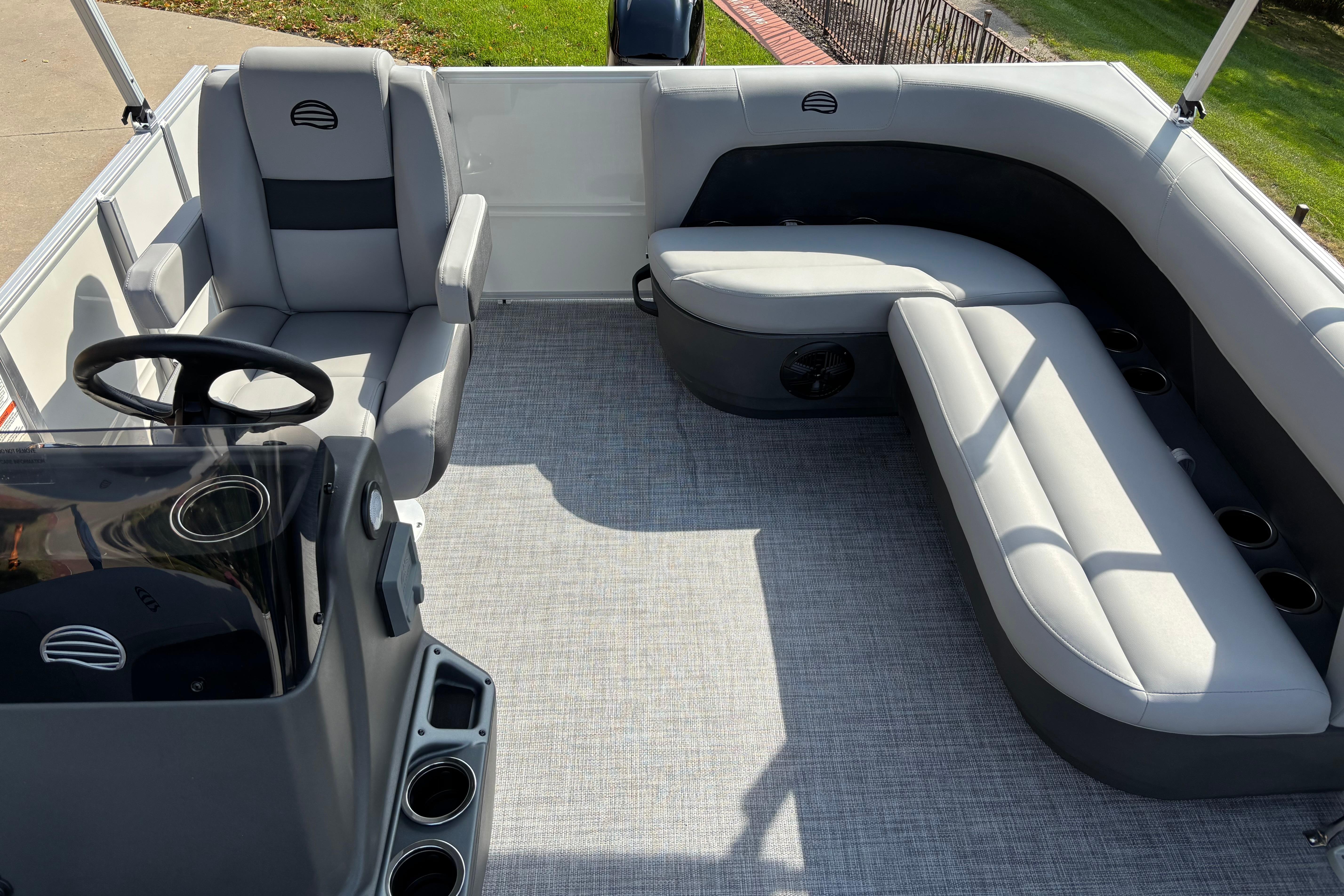 2026 Sun Tracker Party Barge 16 DLX interior with gray seating and steering console.