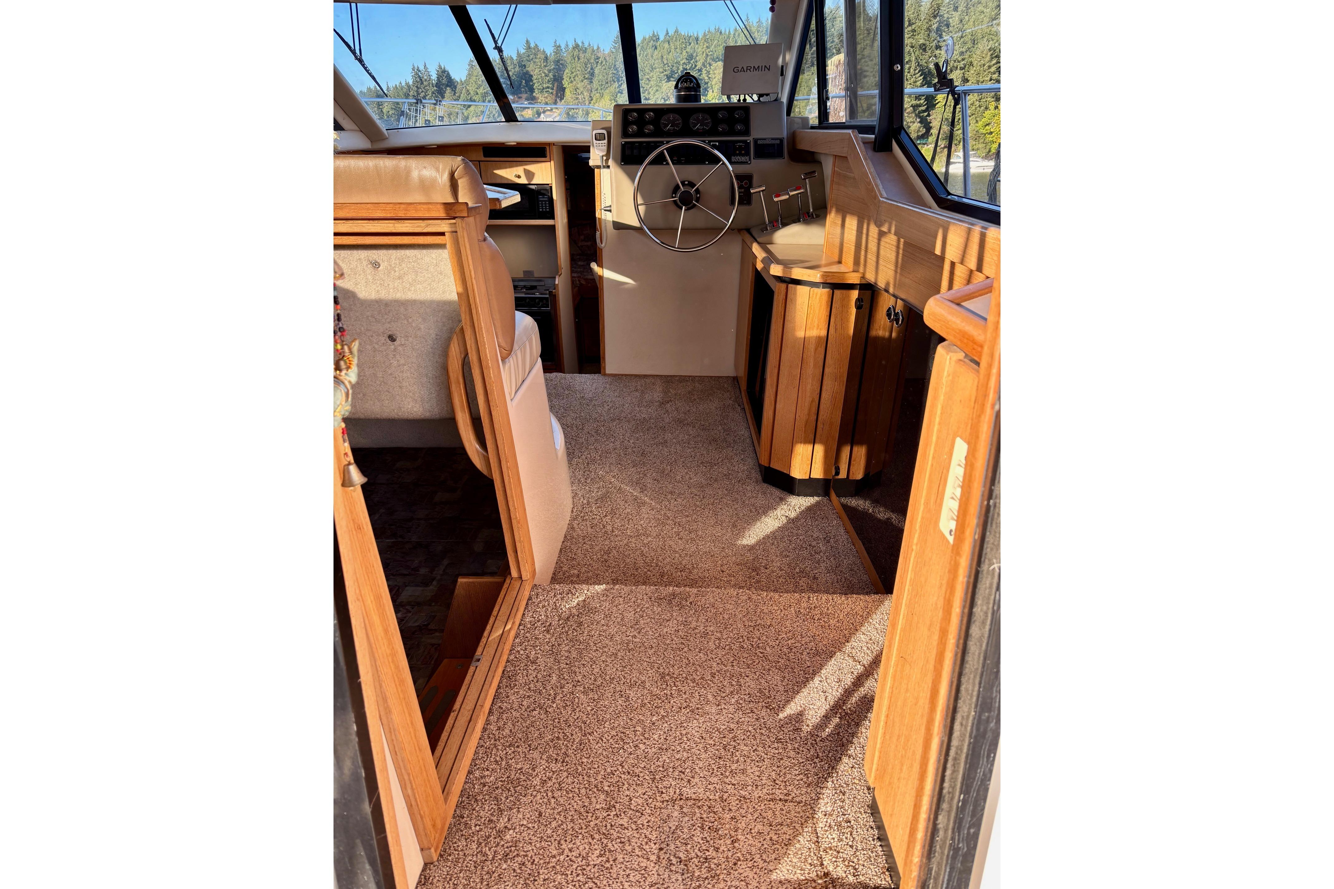 1998 Bayliner 3388 Command Bridge Motoryacht interior with helm, wood accents, and carpeted flooring.