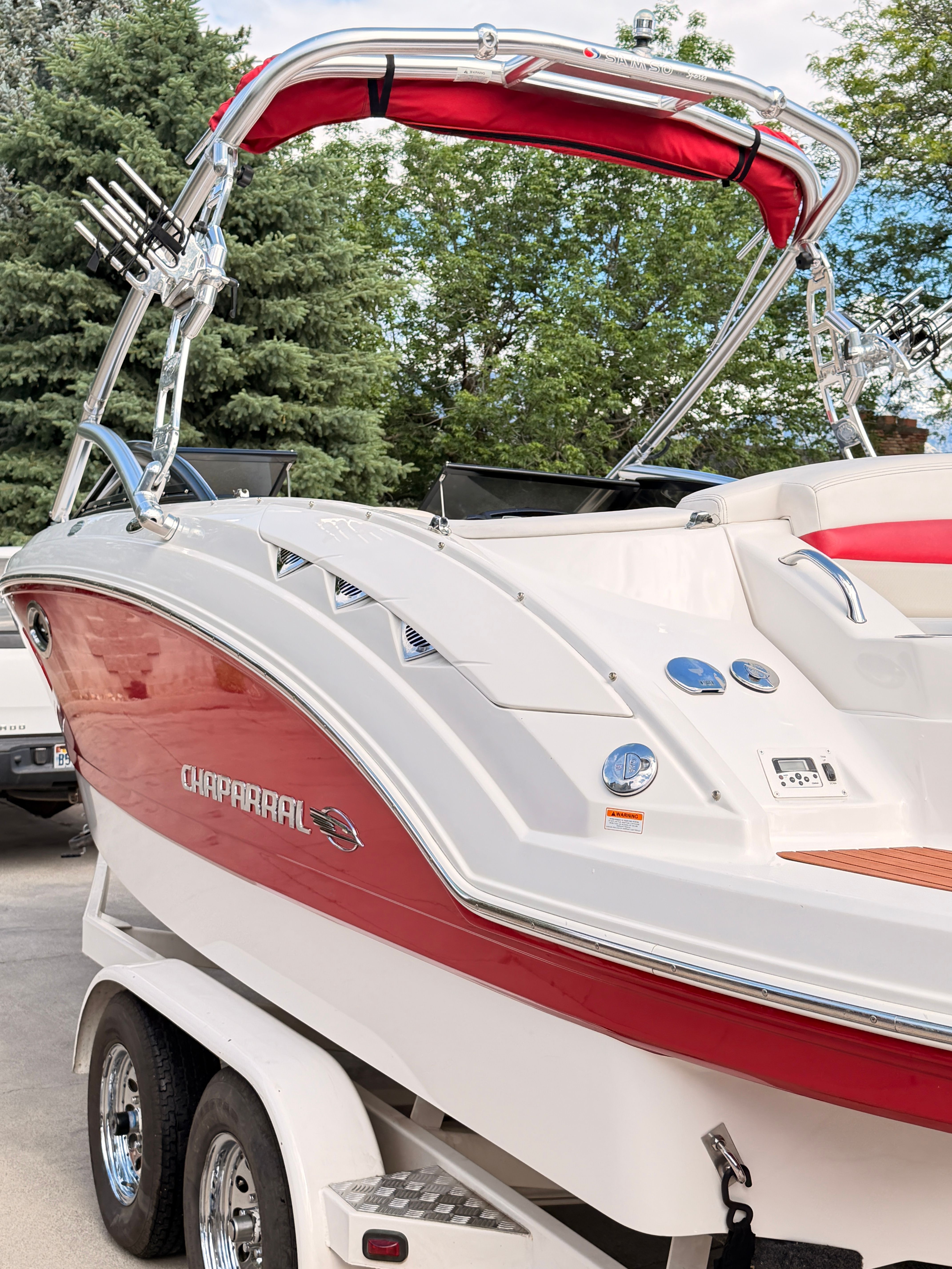 2008 Chaparral Sunesta 224 with a red and white hull, parked on a trailer.