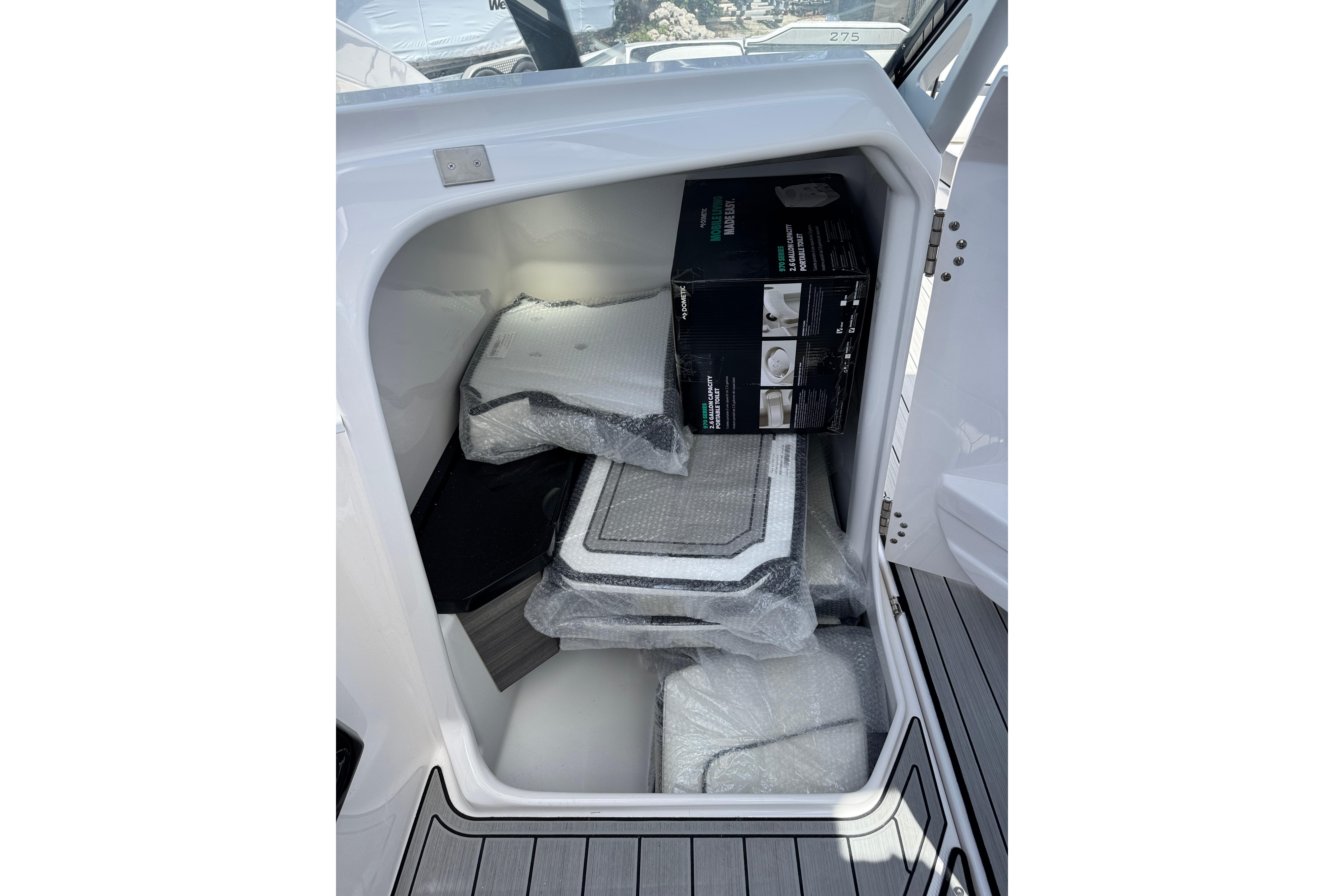 Storage compartment of 2026 Yamaha Boats 275SD, containing packaged items and accessories.