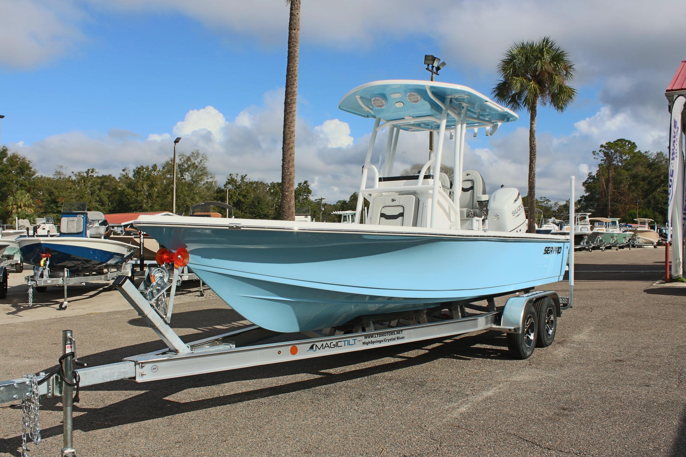 2025 Sea Pro 230 Bay boat on trailer, parked outdoors under a cloudy sky.