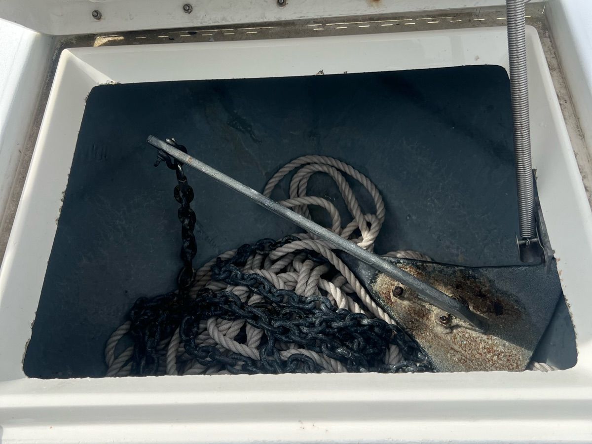 An anchor locker containing an anchor, chain, and ropes.
