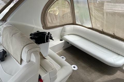 2002 Cruisers Yachts 3372 Express interior with white seating and covered windows.