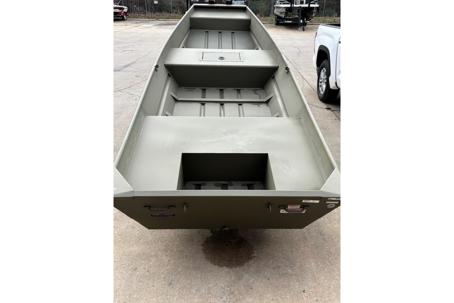 2026 Tracker Grizzly 12 Jon boat, olive green, parked on concrete surface.