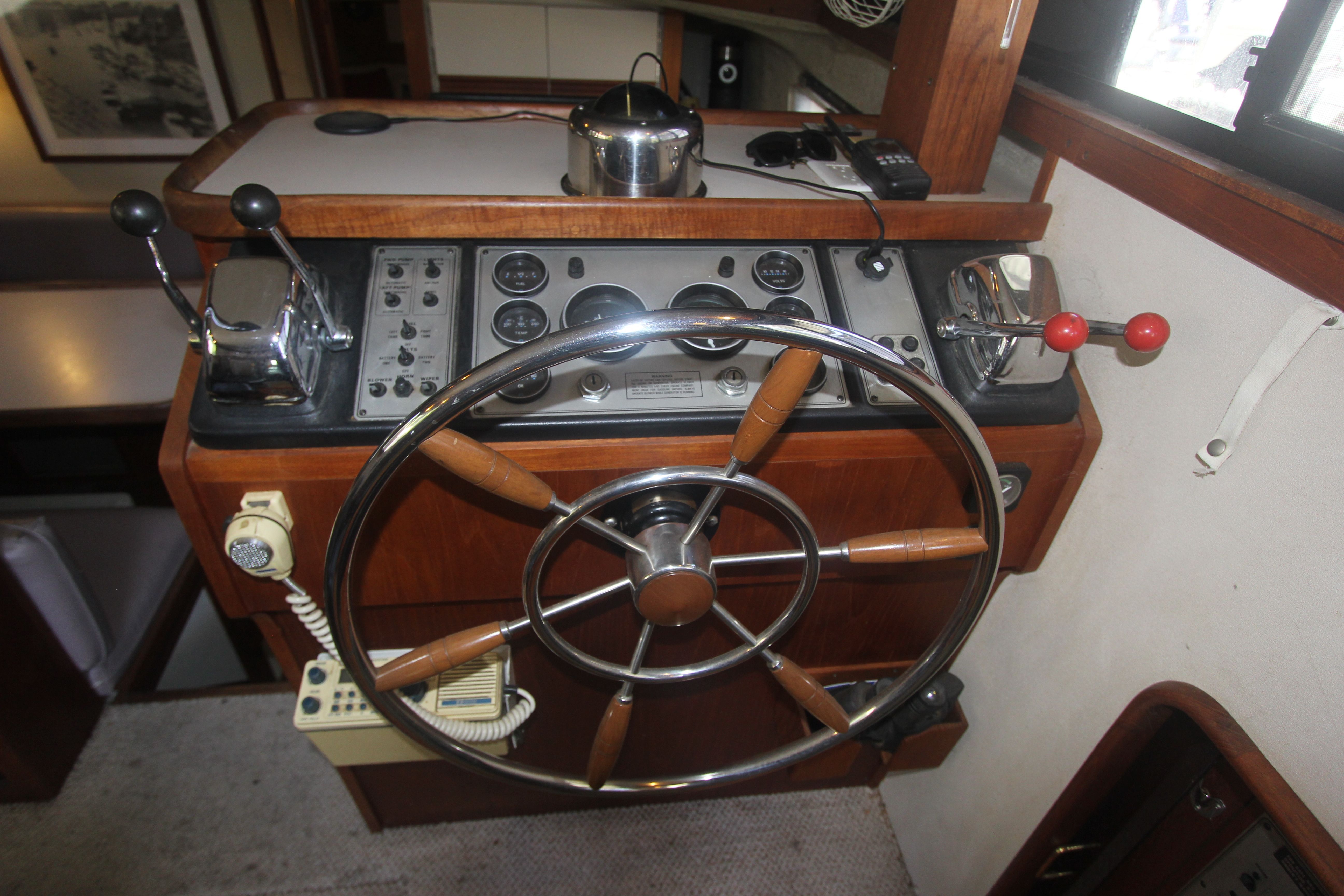 Helm of a 1988 Carver 3607 Aft Cabin Motor Yacht with wooden wheel and instruments.