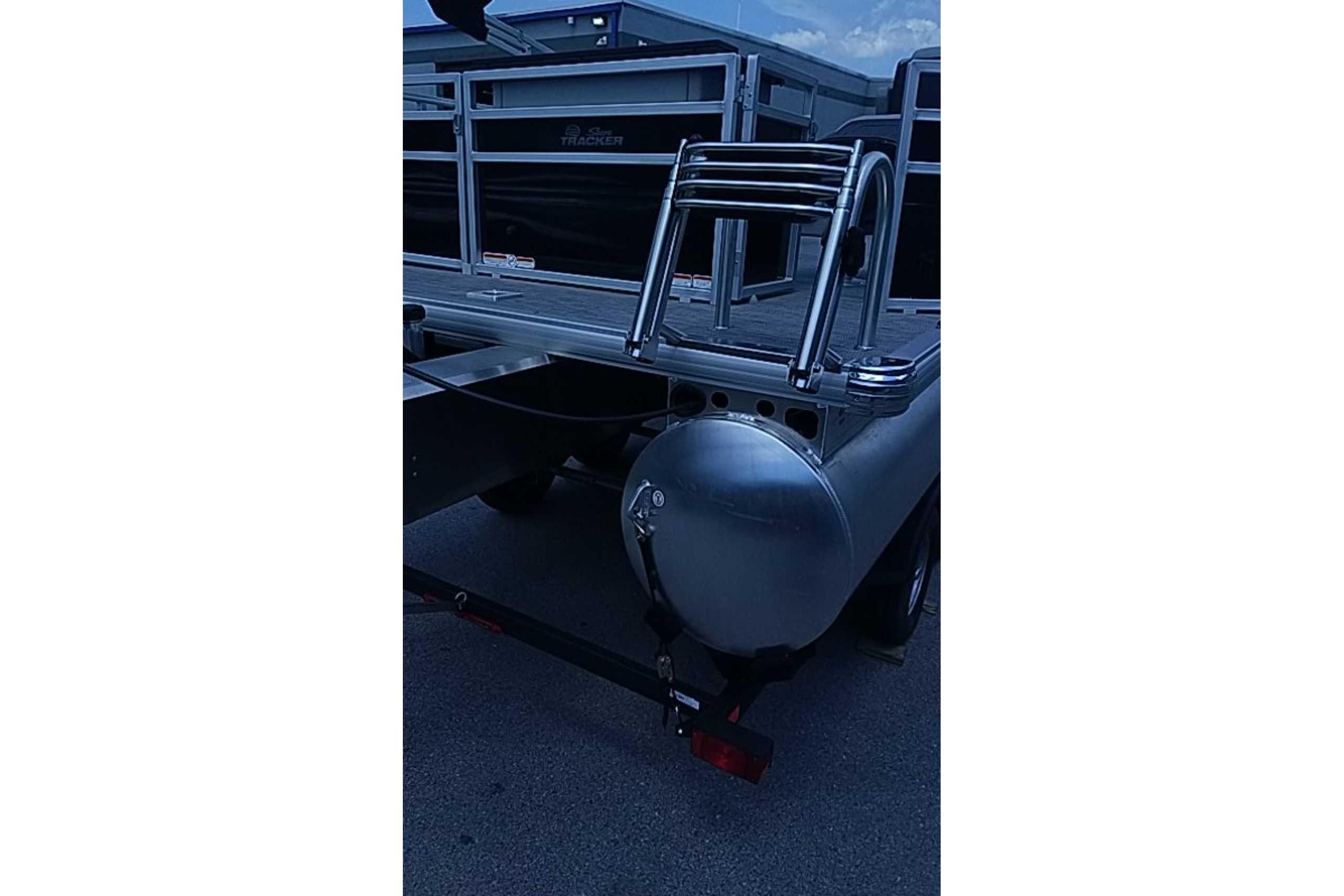 2026 Sun Tracker SportFish 22 DLX pontoon boat rear view with ladder and pontoons.