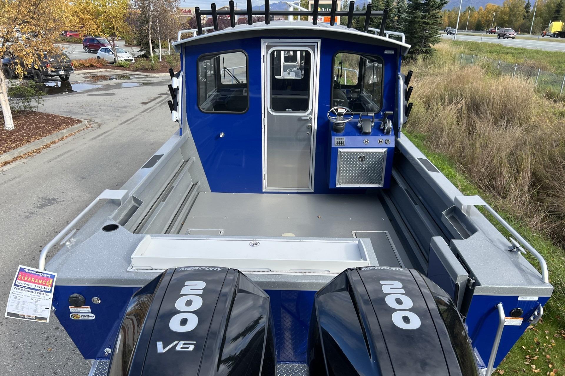 2024 Spartan 26 Maximus Pro XL boat with dual Mercury 200 V6 engines, parked outdoors.