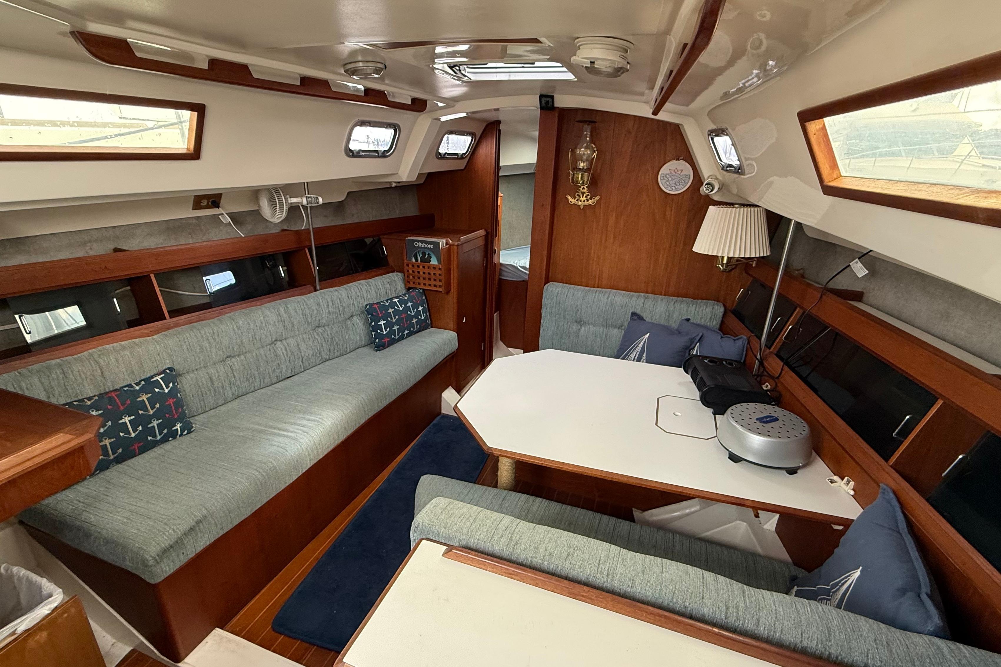 1984 Hunter 31 yacht interior with cozy seating, wooden accents, and nautical decor.