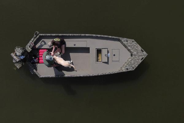 Aerial view of 2025 SeaArk 1752 Slayer Pro boat with two people and a dog.