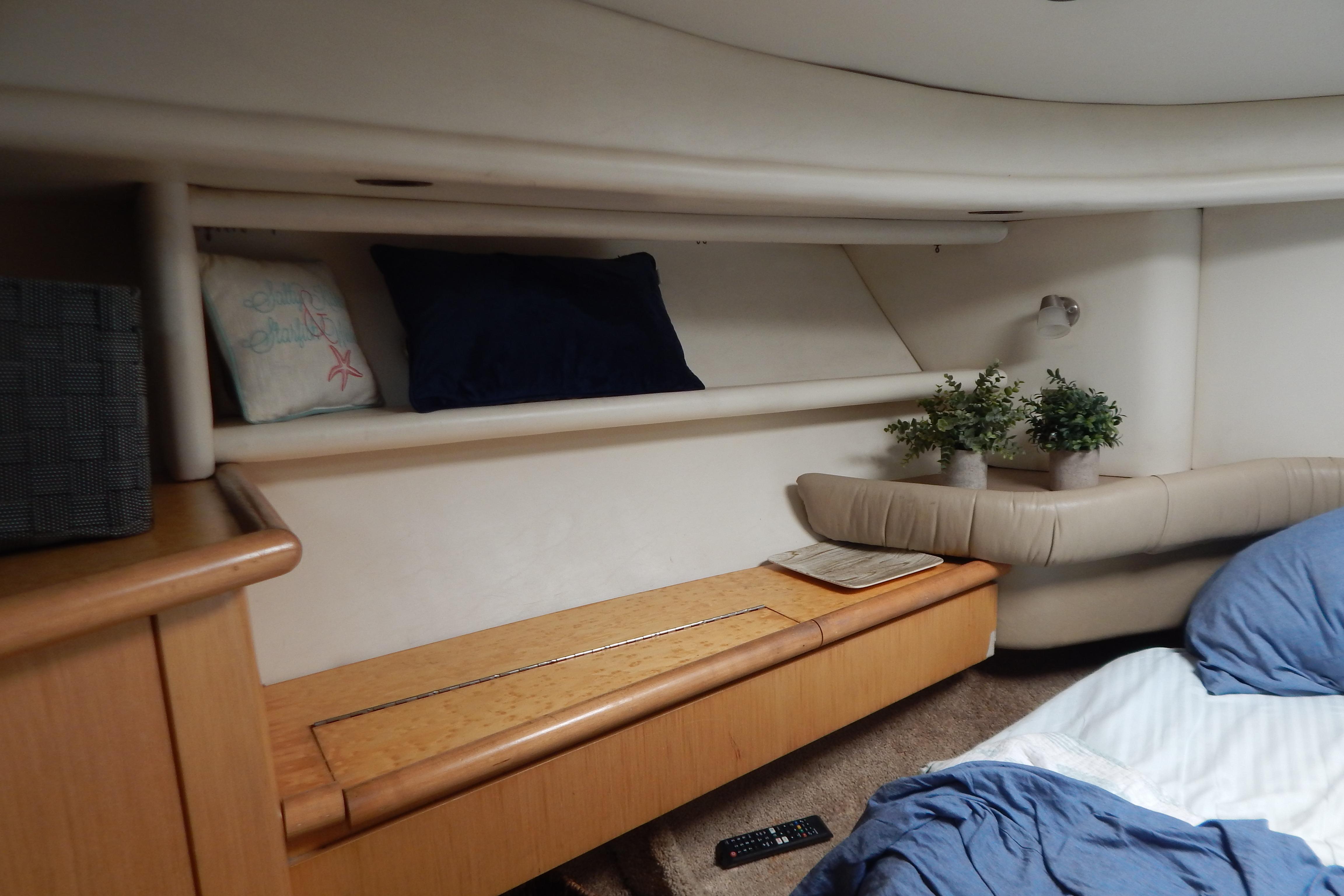 Cozy interior of 1998 Magnum 4100 SCR yacht with cushions and plants.