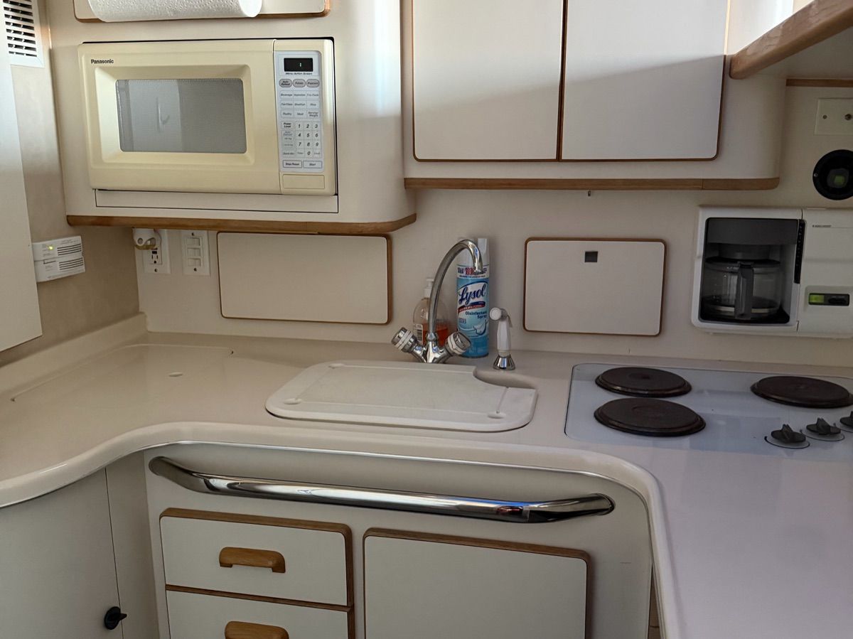 Interior view of a 1996 Sea Ray 370 Sedan Bridge galley with stove and microwave.