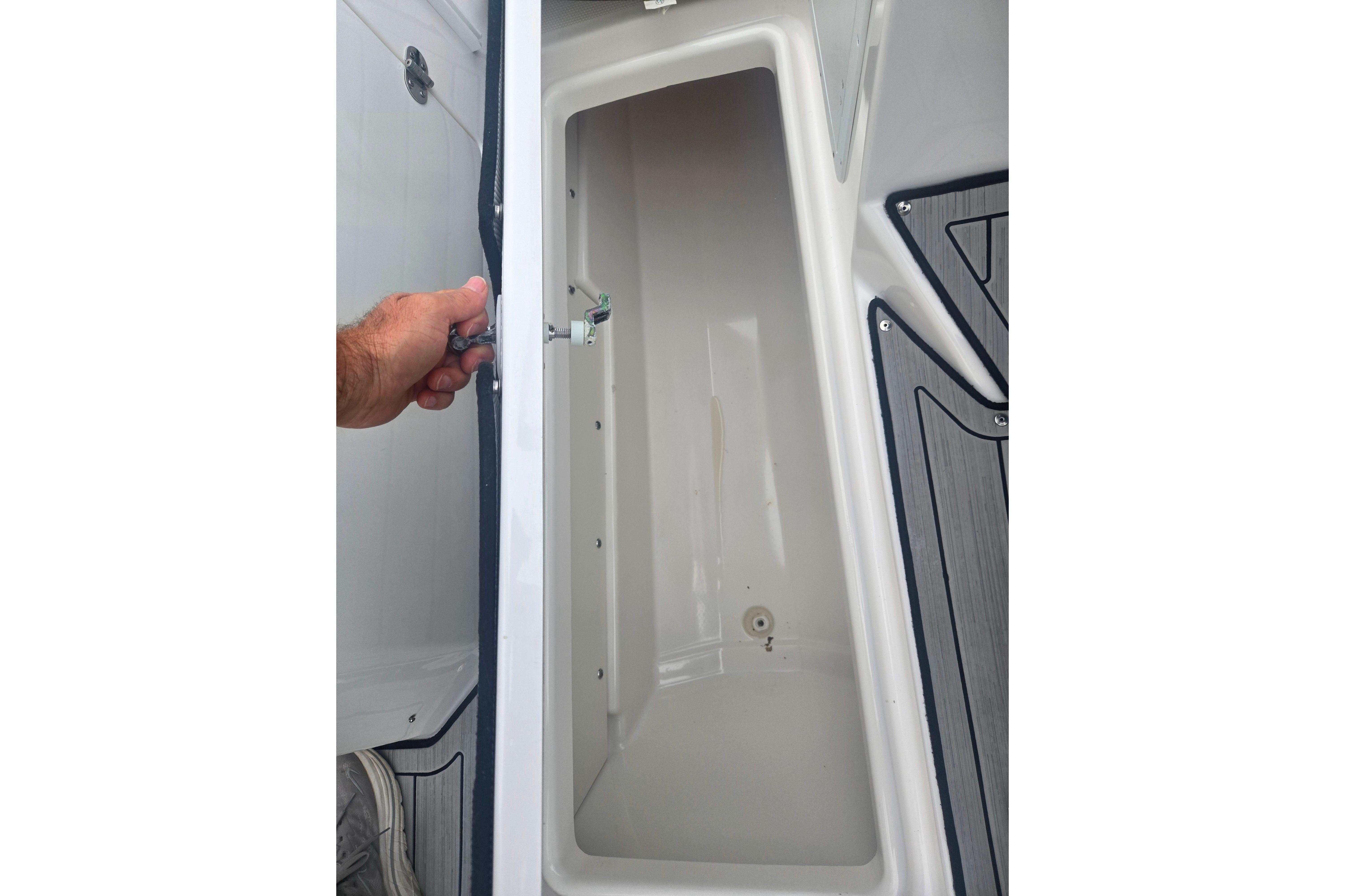 Open storage compartment on 2023 Yamaha Boats 252S, showcasing interior space and design.