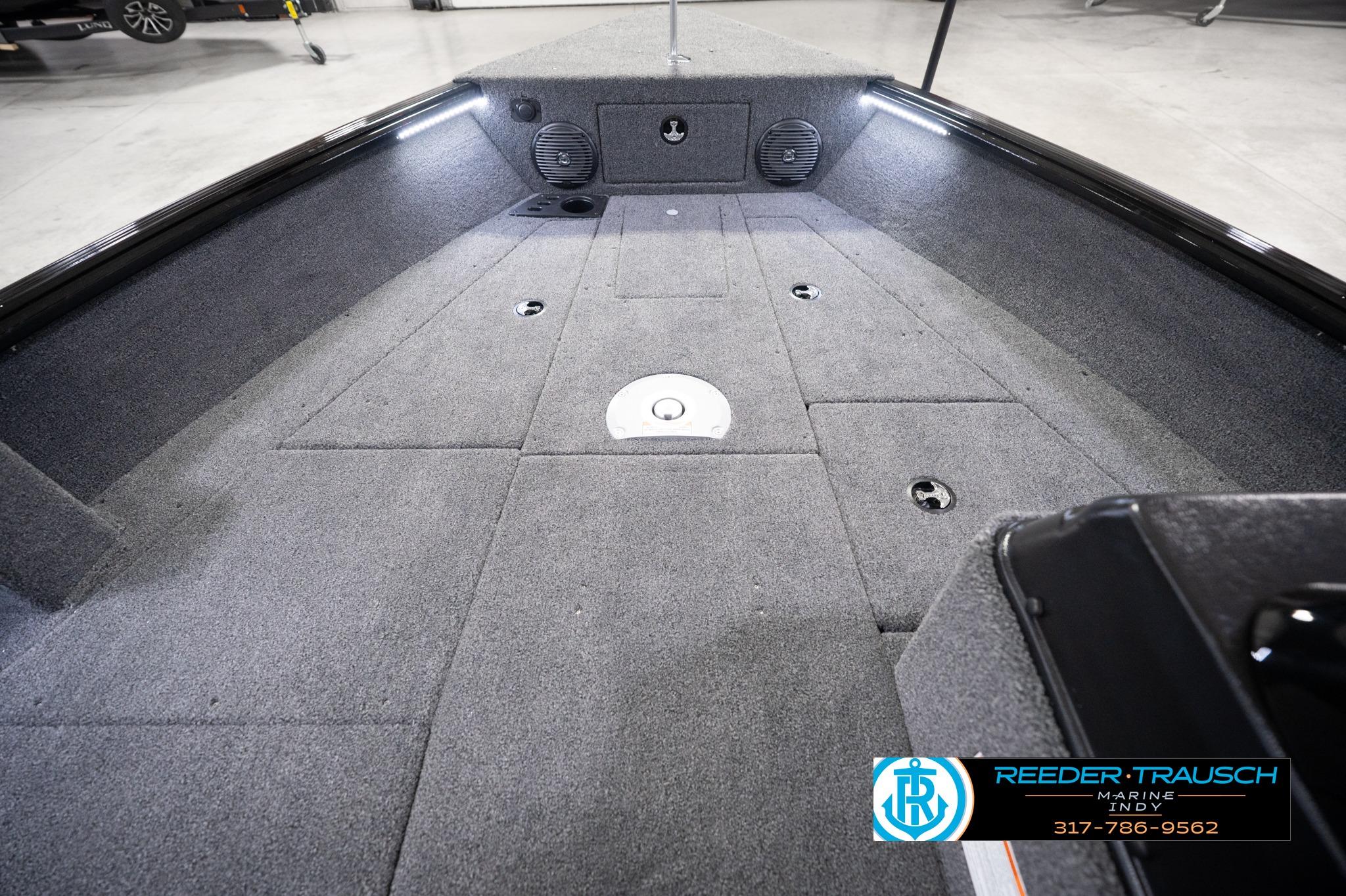 2026 Lund 1775 Impact XS SS boat interior with carpeted deck and storage compartments.