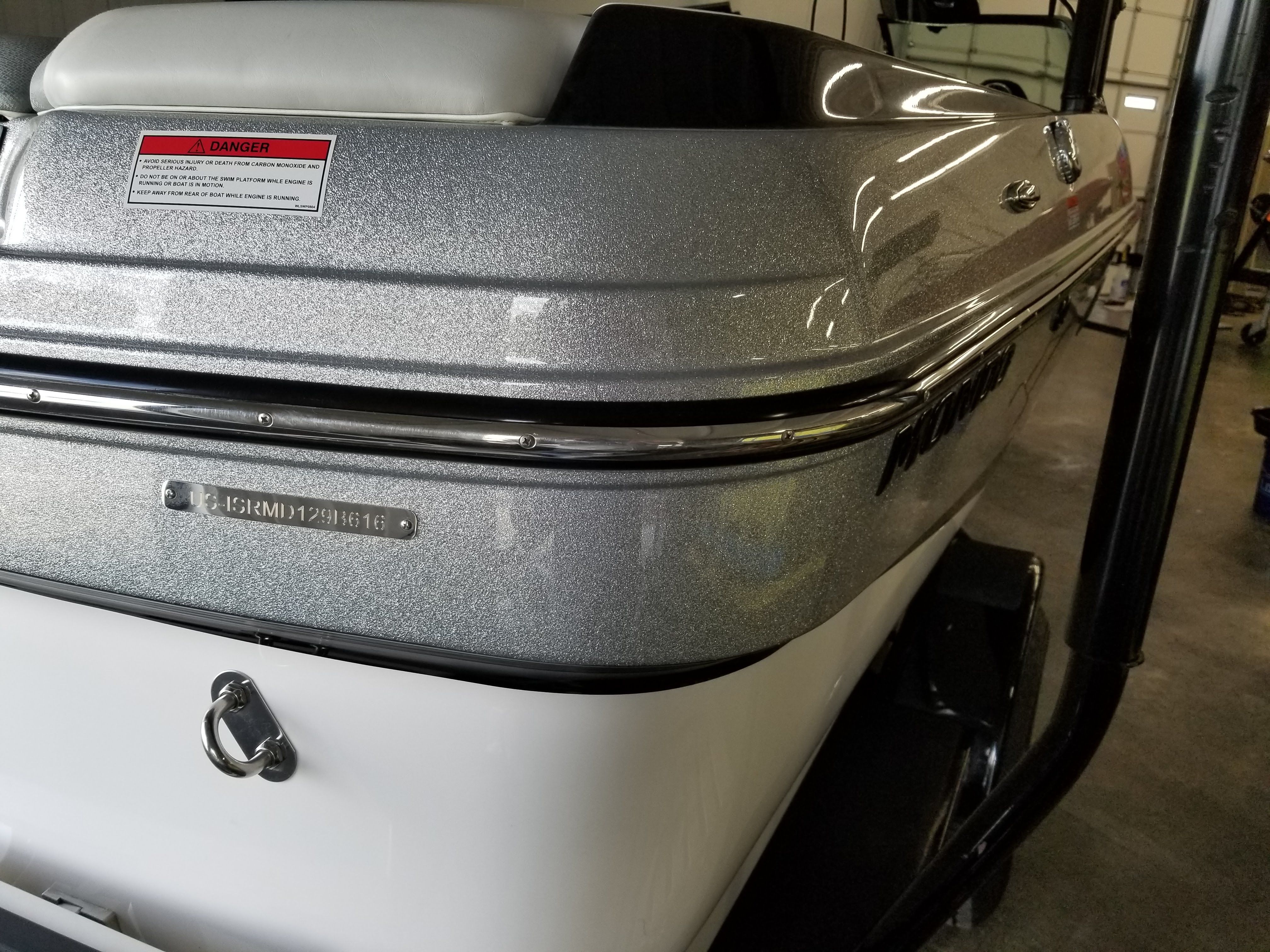 The image shows the rear of a 2016 Moomba Mondo boat in a workshop.