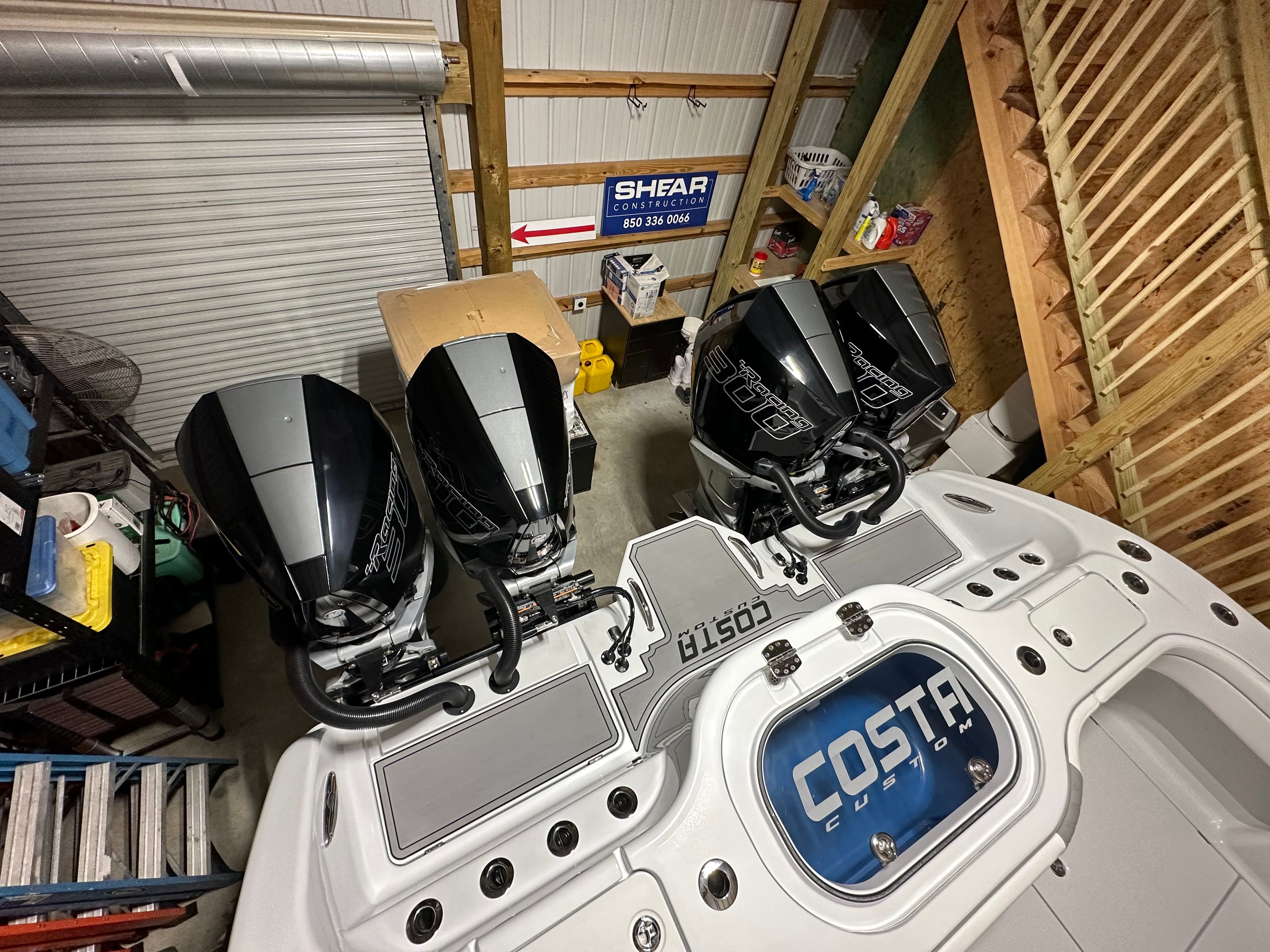 Four powerful outboard engines on a Costa Custom boat in storage.