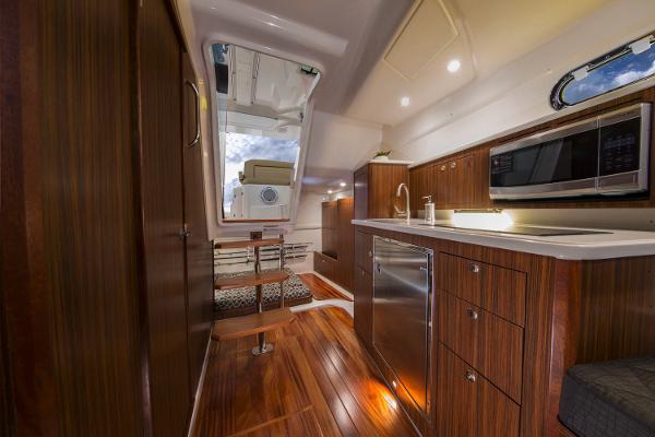 Manufacturer Provided Image: 2019 Pursuit OS 355 Offshore interior with modern kitchen and cozy sleeping area.