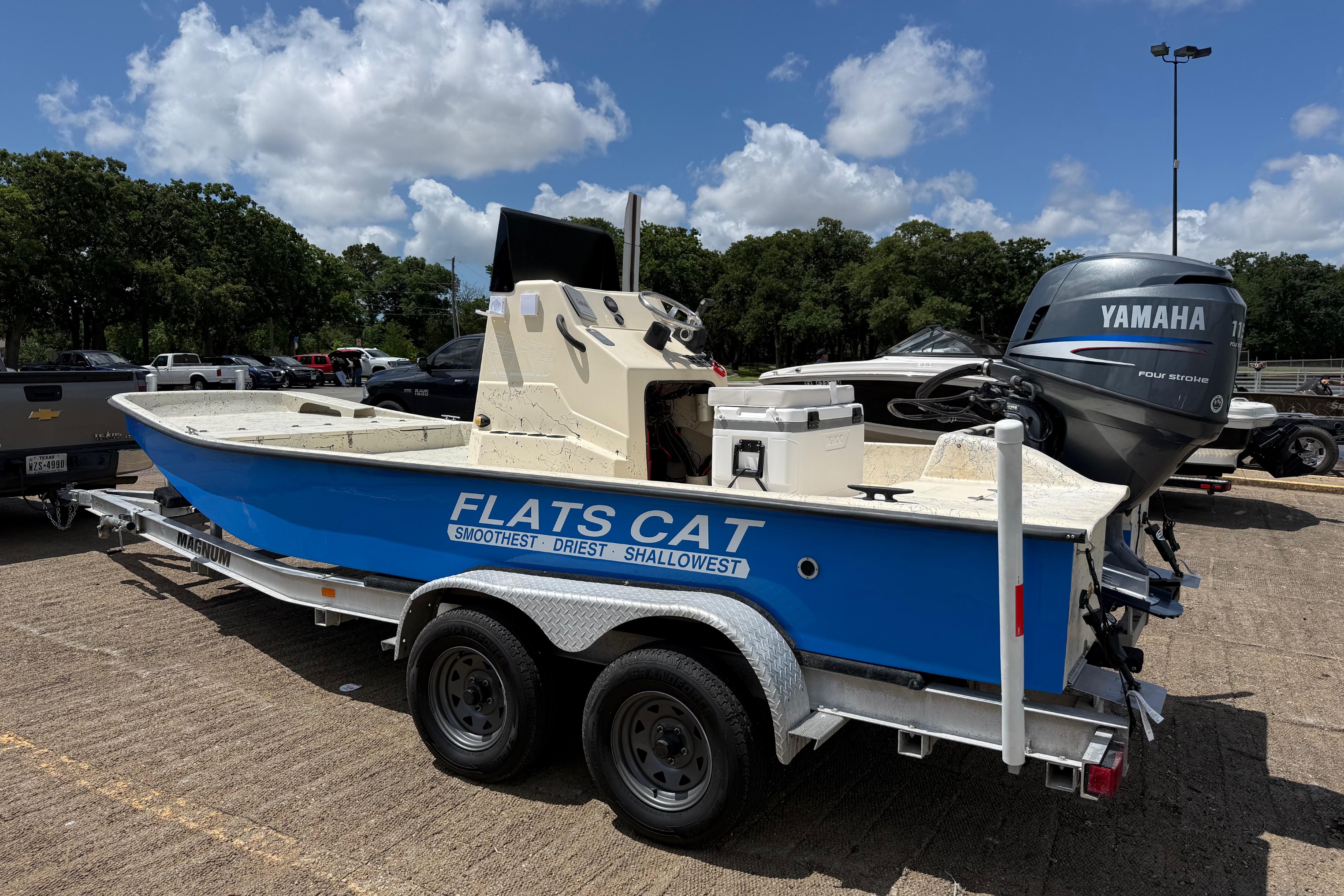 Blue 2007 Flats Cat 19 boat on trailer with Yamaha motor, parked outdoors.