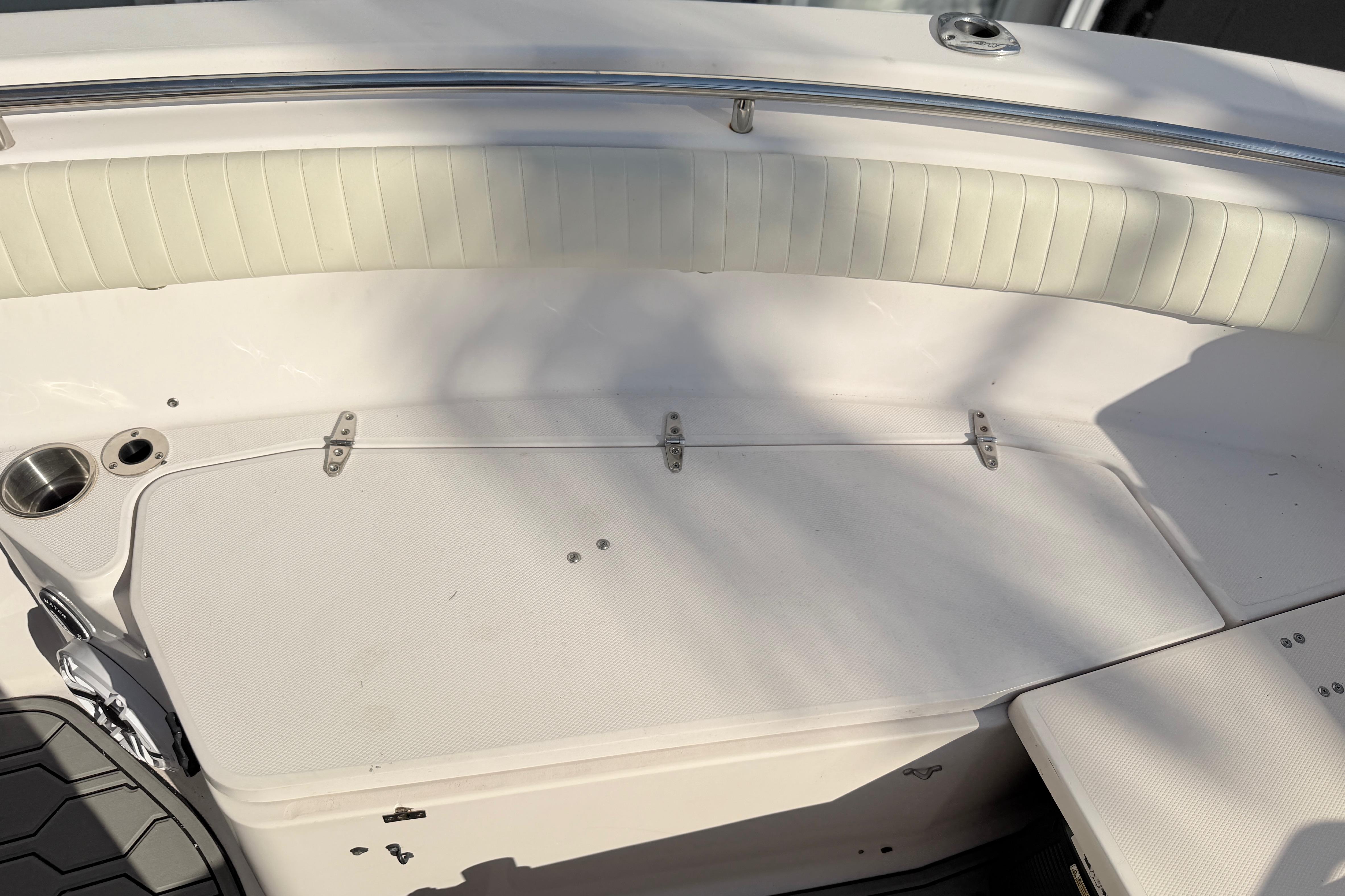 2004 Grady White 273 boat interior with white cushioned seating and stainless steel cup holder.