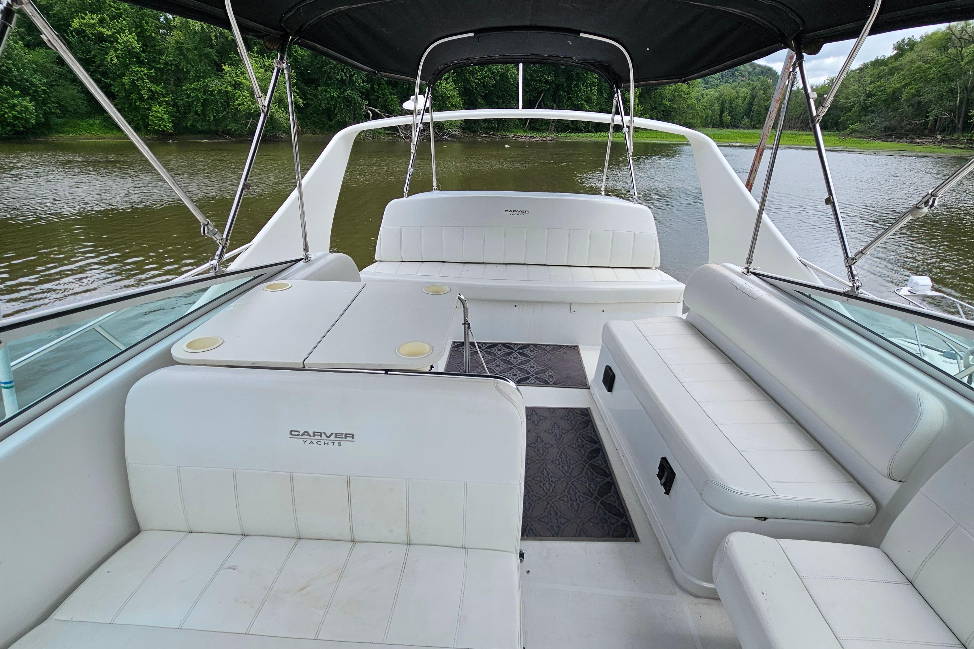 1999 Carver 350 Mariner yacht interior with white seating, docked on a serene river.