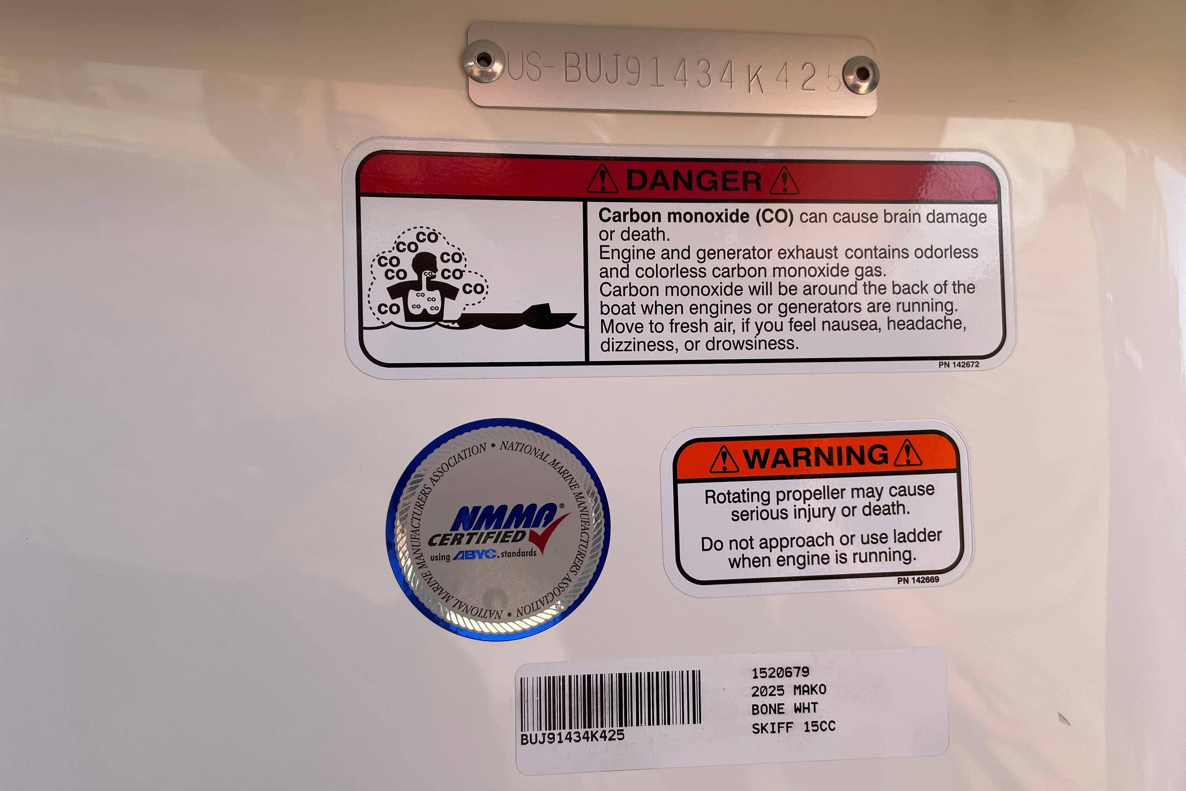 Warning labels on 2025 Mako Pro Skiff 15 CC boat, highlighting carbon monoxide and propeller dangers.