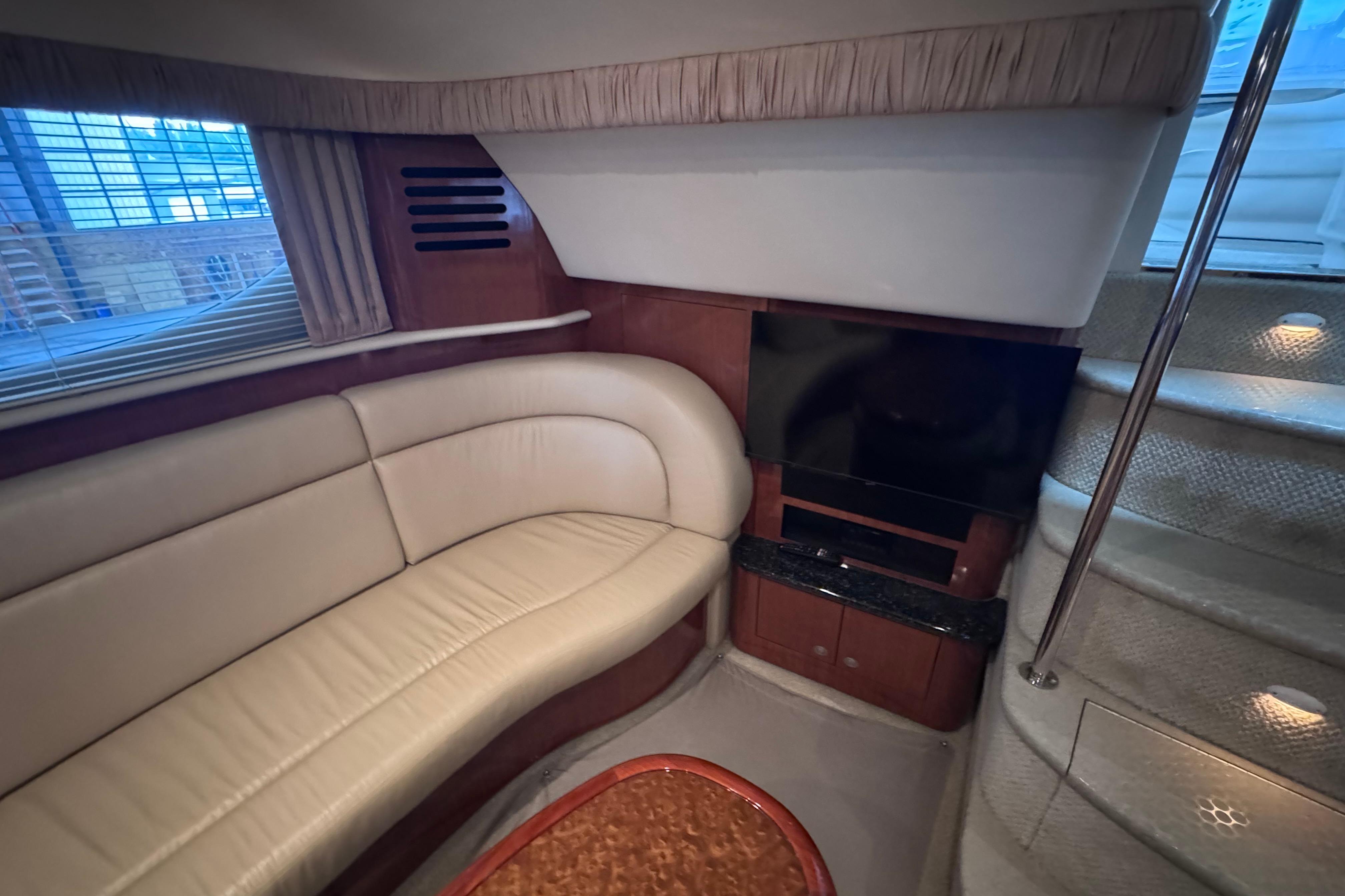 Luxurious interior of 2004 Sea Ray 390 Motor Yacht with leather seating and TV.