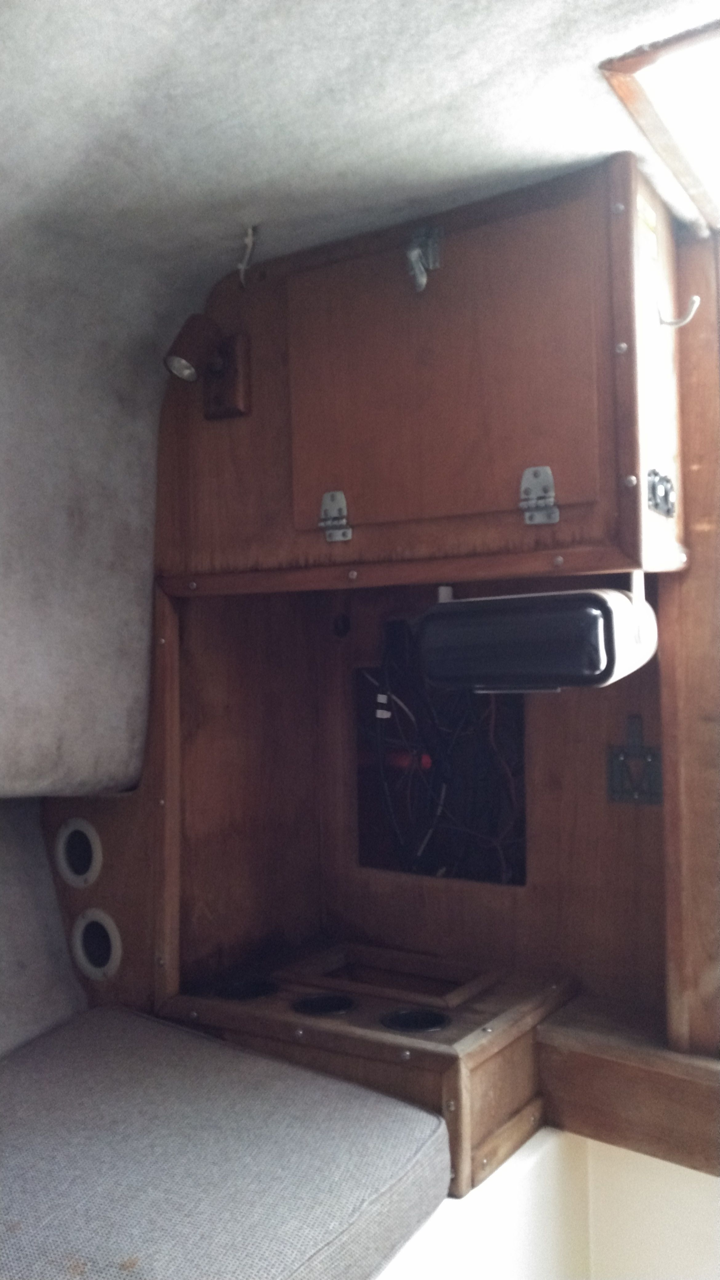 Interior of a boat with wooden cabinetry and gray upholstery.