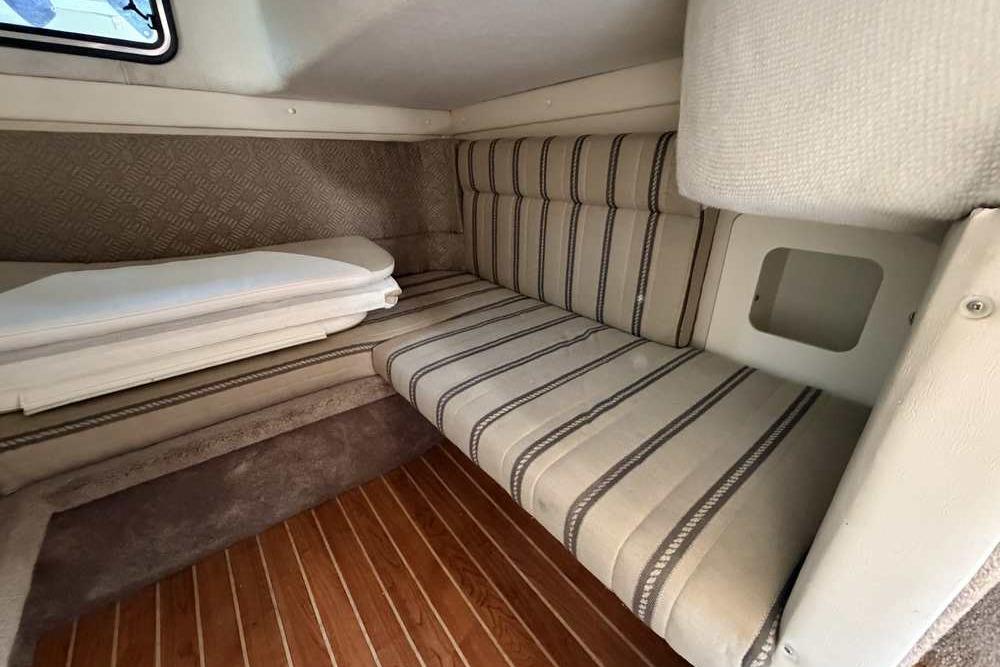 Interior cabin of a 2001 Monterey 282 Cruiser with striped upholstery and wooden flooring.