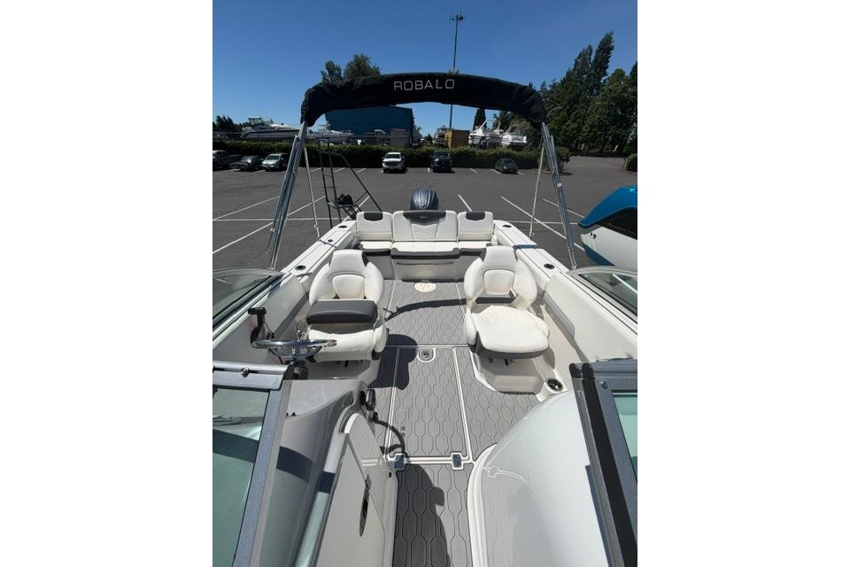 2024 Robalo R207 Dual Console boat interior with seating and canopy in a parking lot.