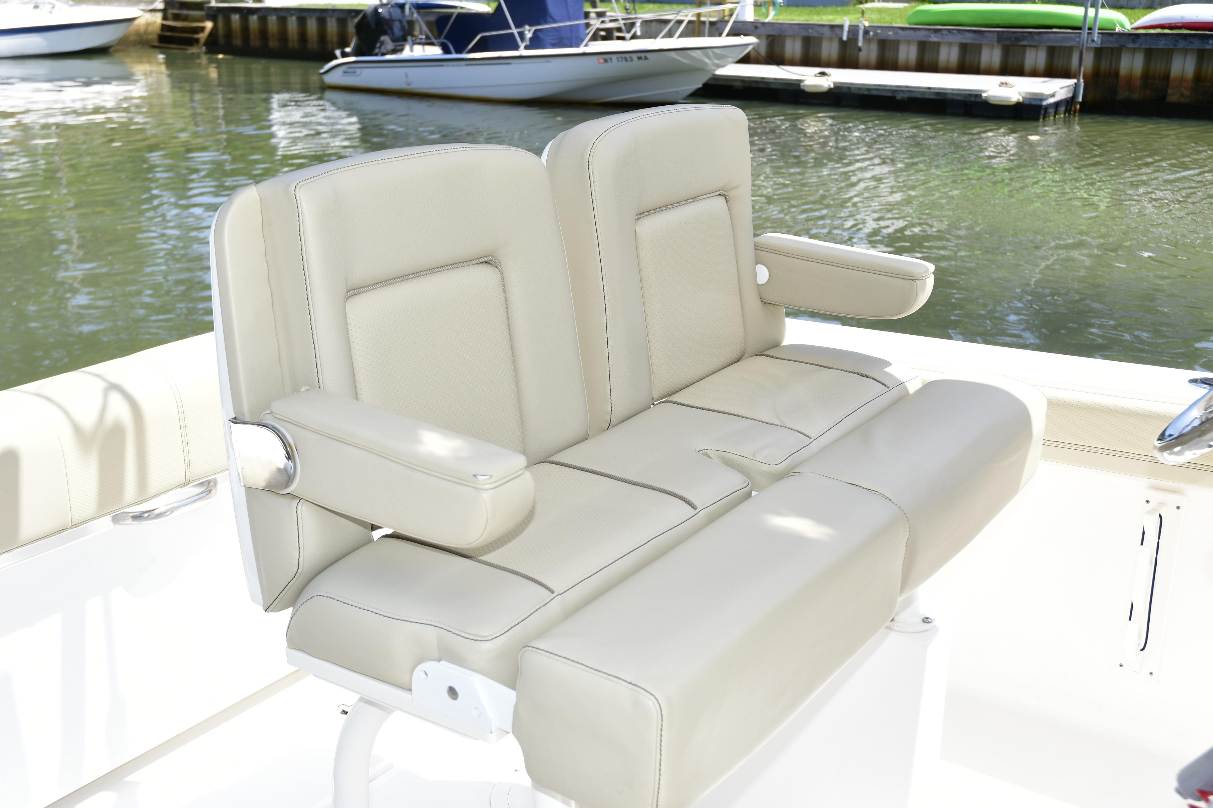 2020 Pursuit C 238 Center Console boat with beige seating at a marina.