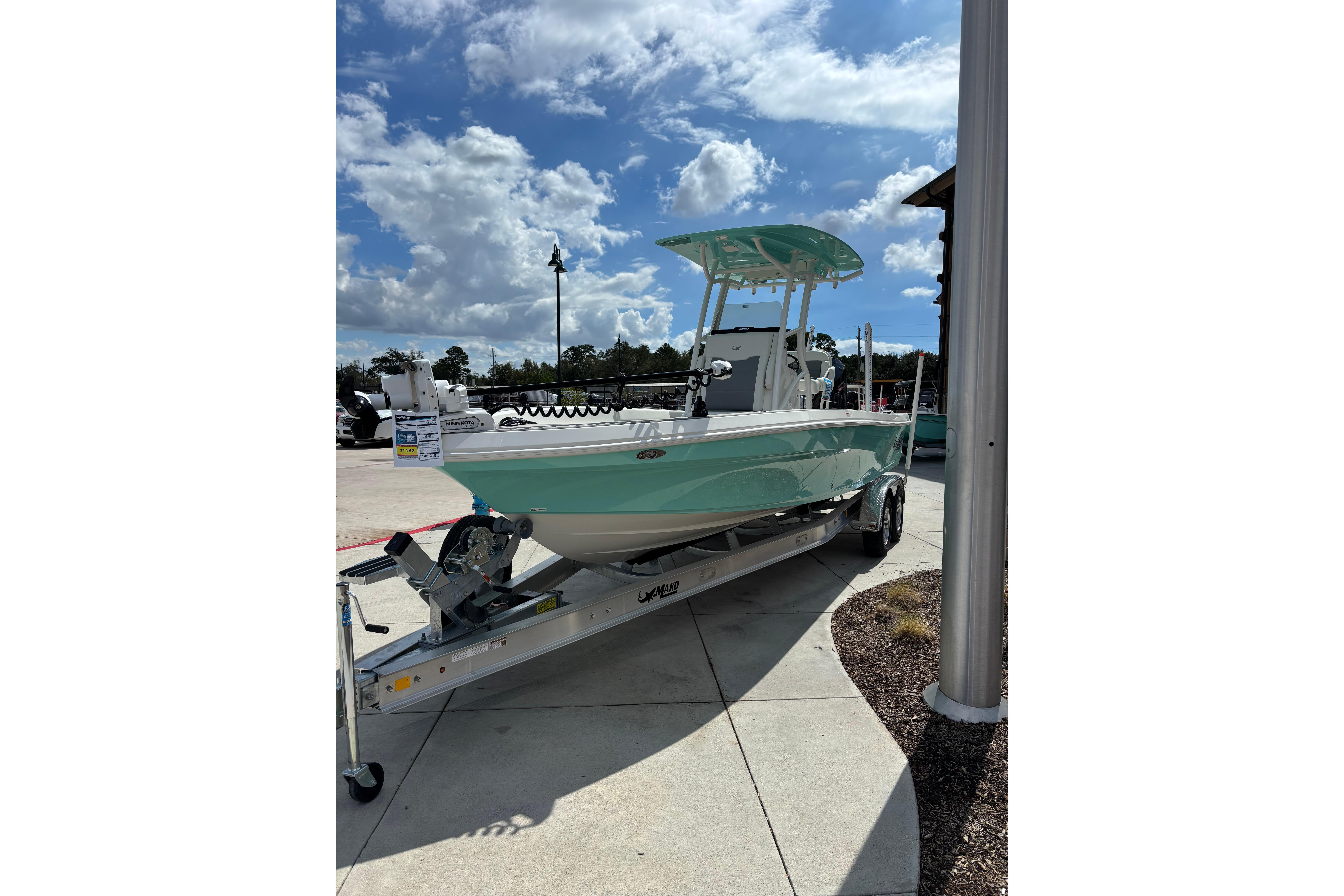 2026 Mako 24 APEX boat on trailer under a sunny sky.