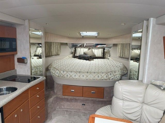 Interior of a 2002 Formula PC 37 with a cozy bed and kitchenette.