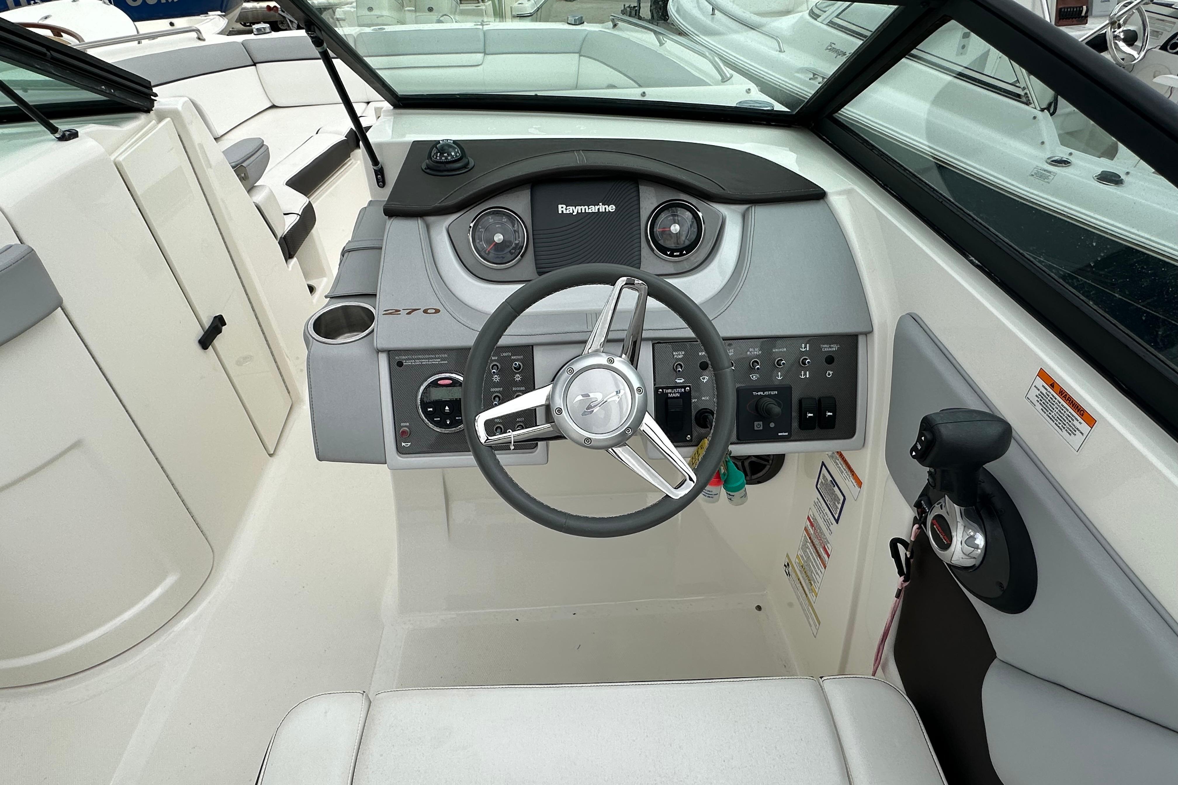 2016 Sea Ray 270 Sundeck boat cockpit with steering wheel and control panel.