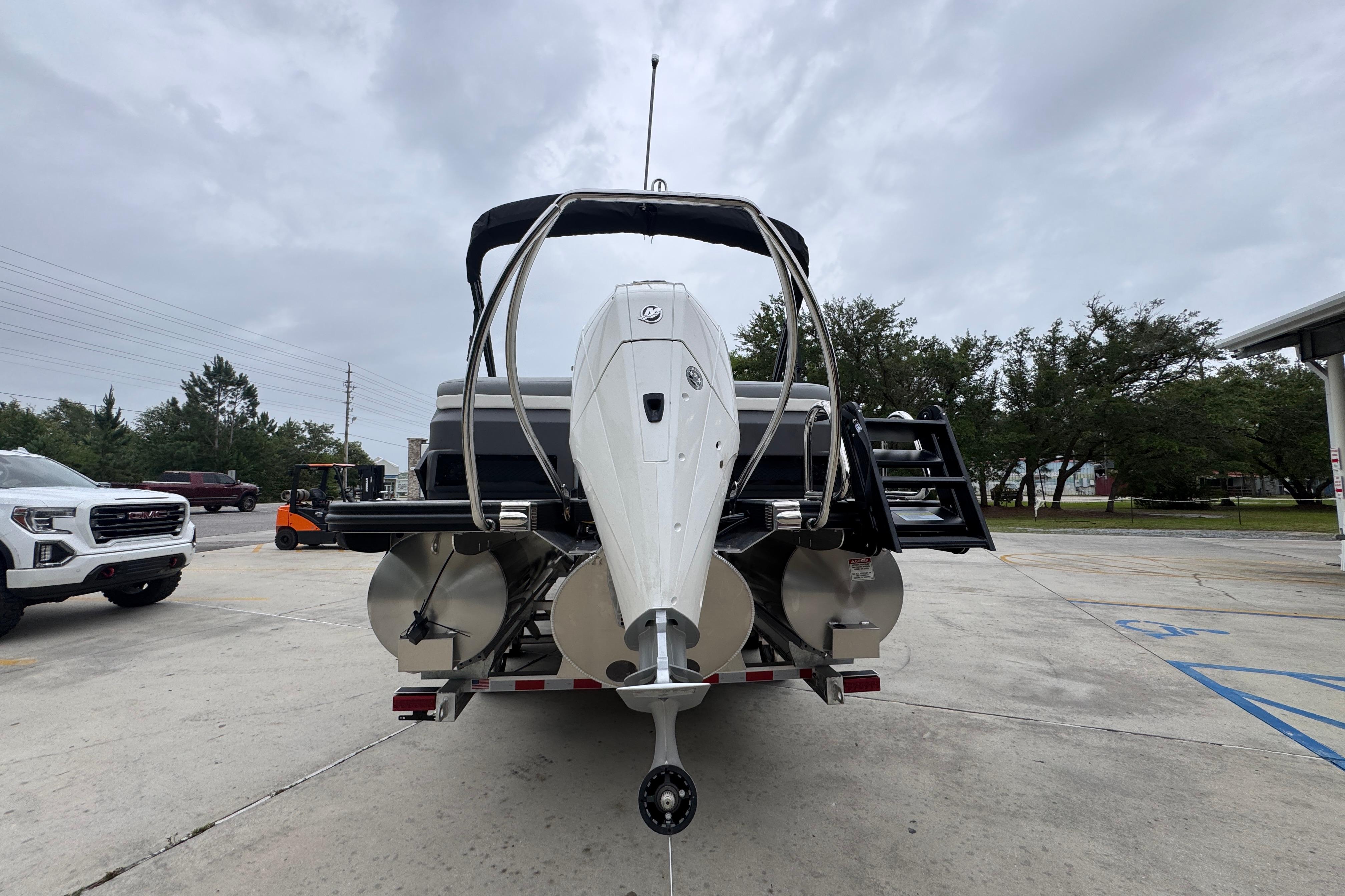 2027 Bennington 24 MFB boat on trailer, rear view, parked outdoors.