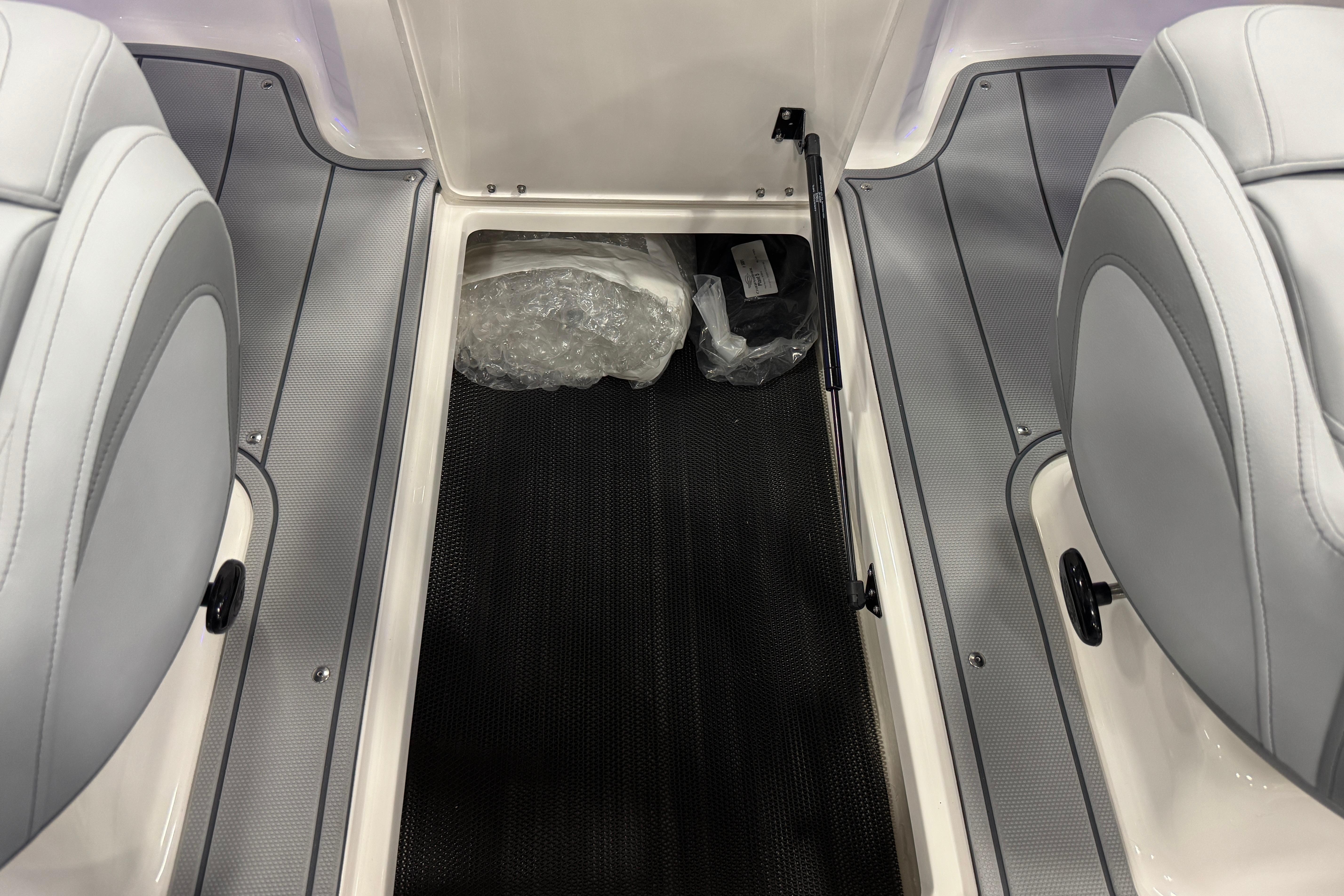 Interior view of 2026 Chaparral 21 SSi boat, featuring seating and storage area.