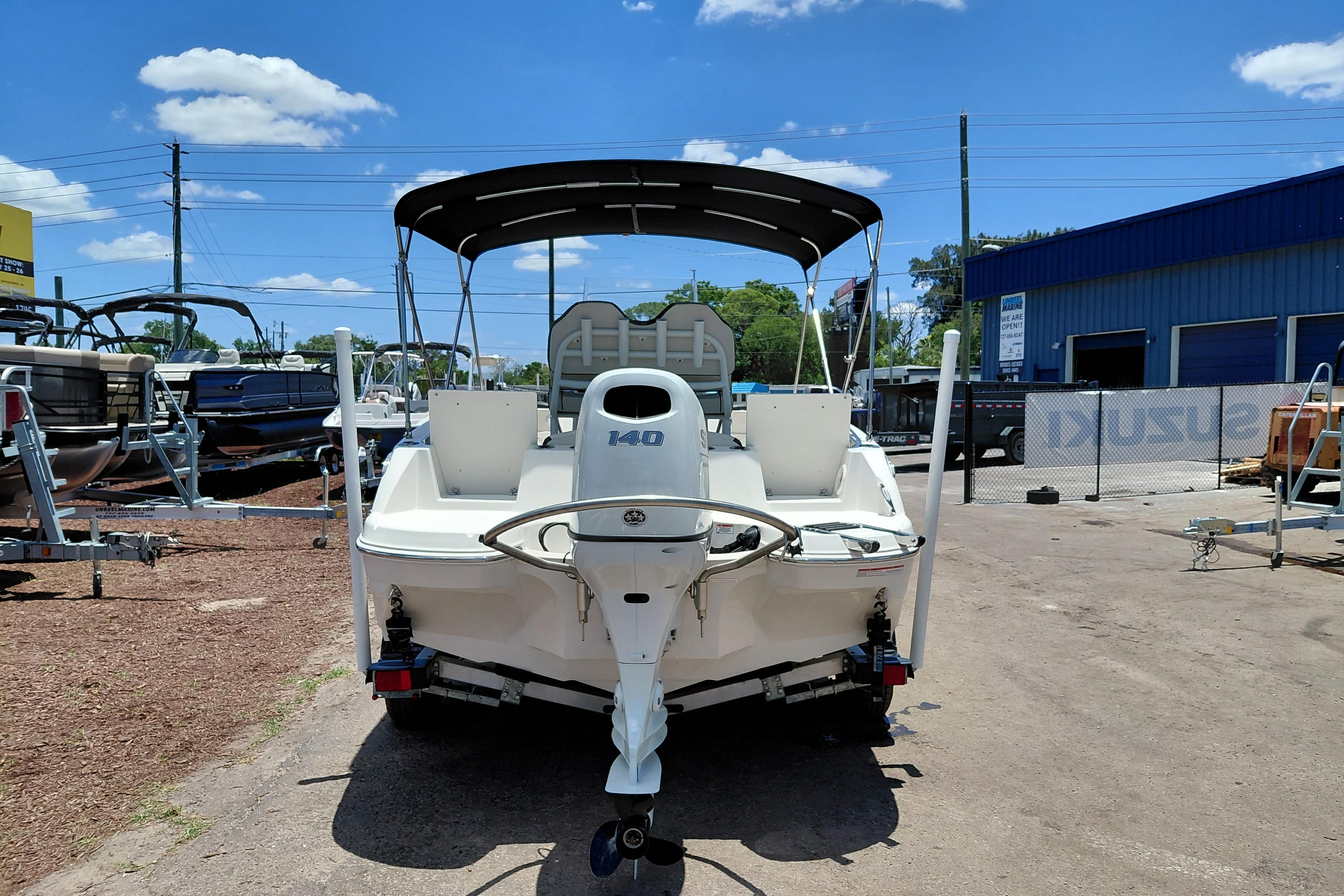 2023 Stingray 206 CC boat with canopy, parked outdoors under a clear blue sky.