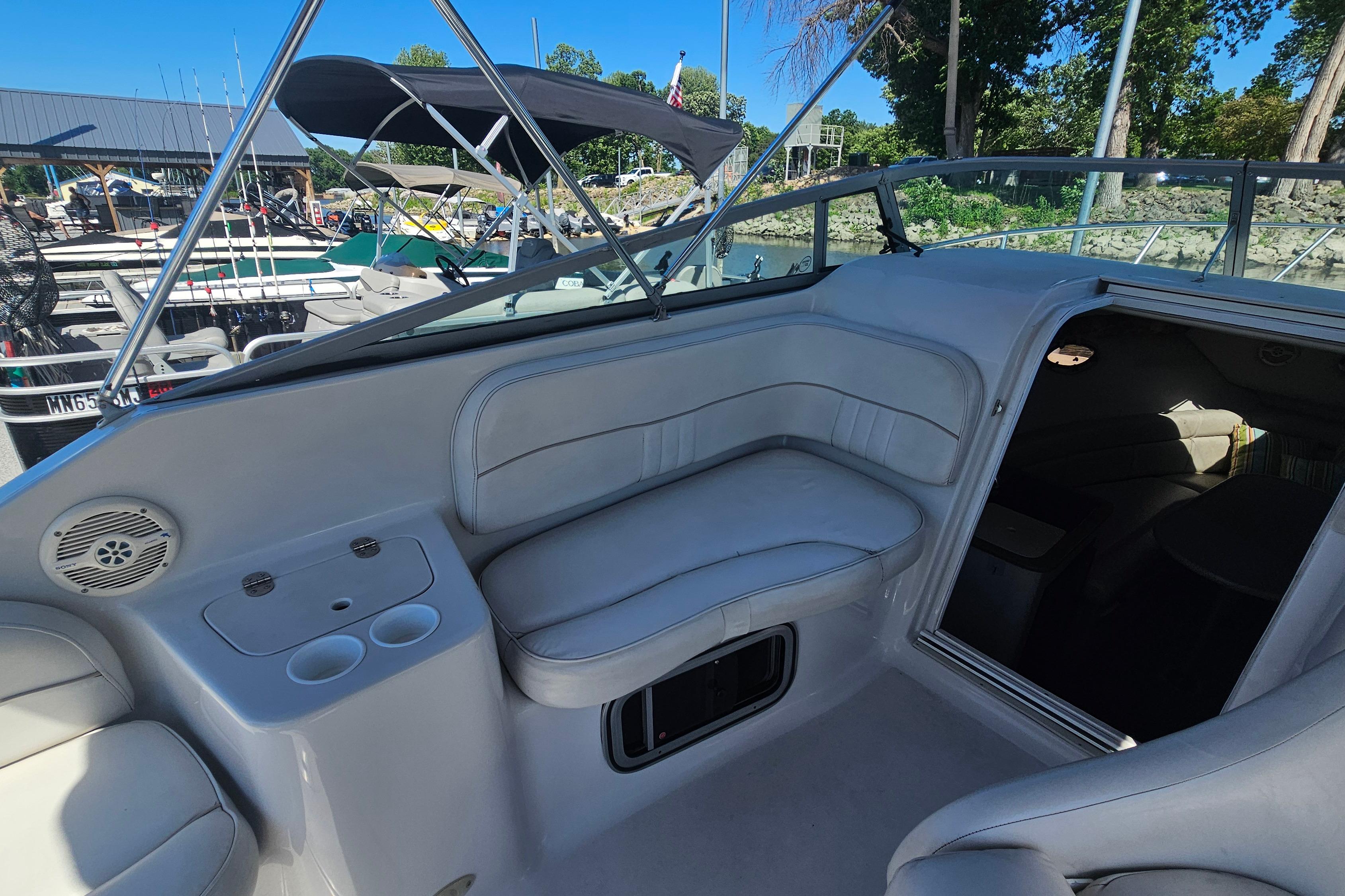2000 Crownline 242 CR boat interior with seating and cabin entrance at marina.