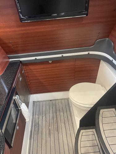 2017 Mystic Powerboats M4200 interior bathroom with wooden paneling and modern amenities.