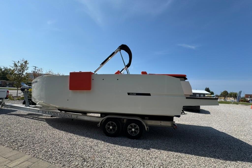 2020 De Antonio Yachts D28 on trailer at Elk Rapids Marina under clear blue sky.