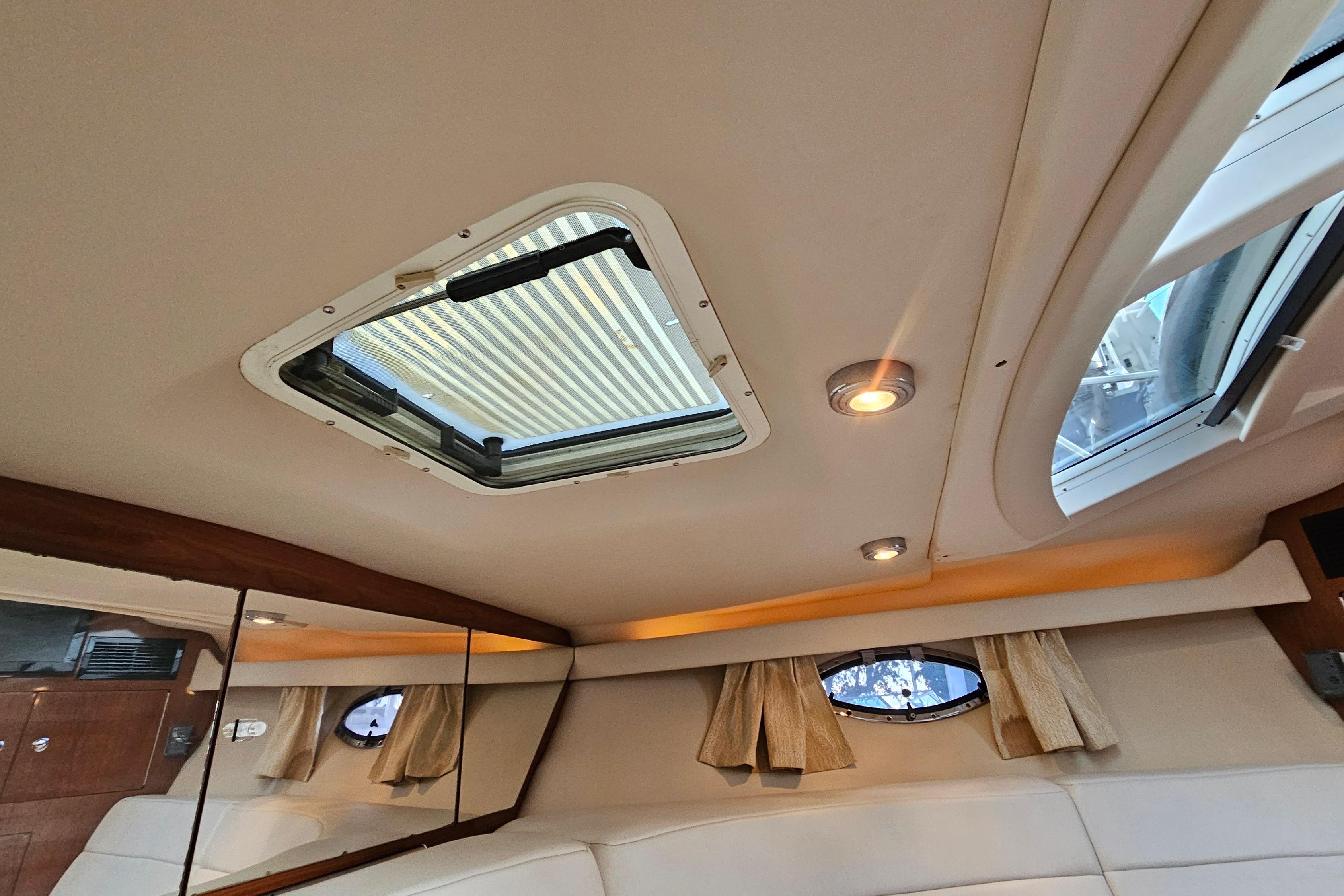 Interior cabin view of a 2005 Regal 3060 Window Express yacht with skylight and lighting.