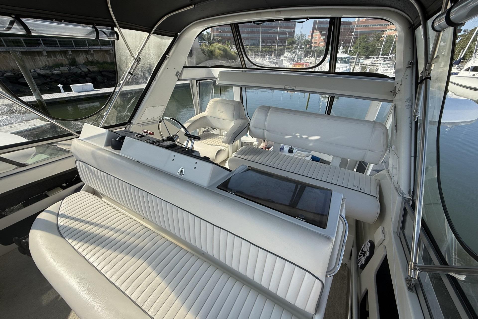 Interior of 1993 Carver 350 Motor Yacht with white seating and marina view.