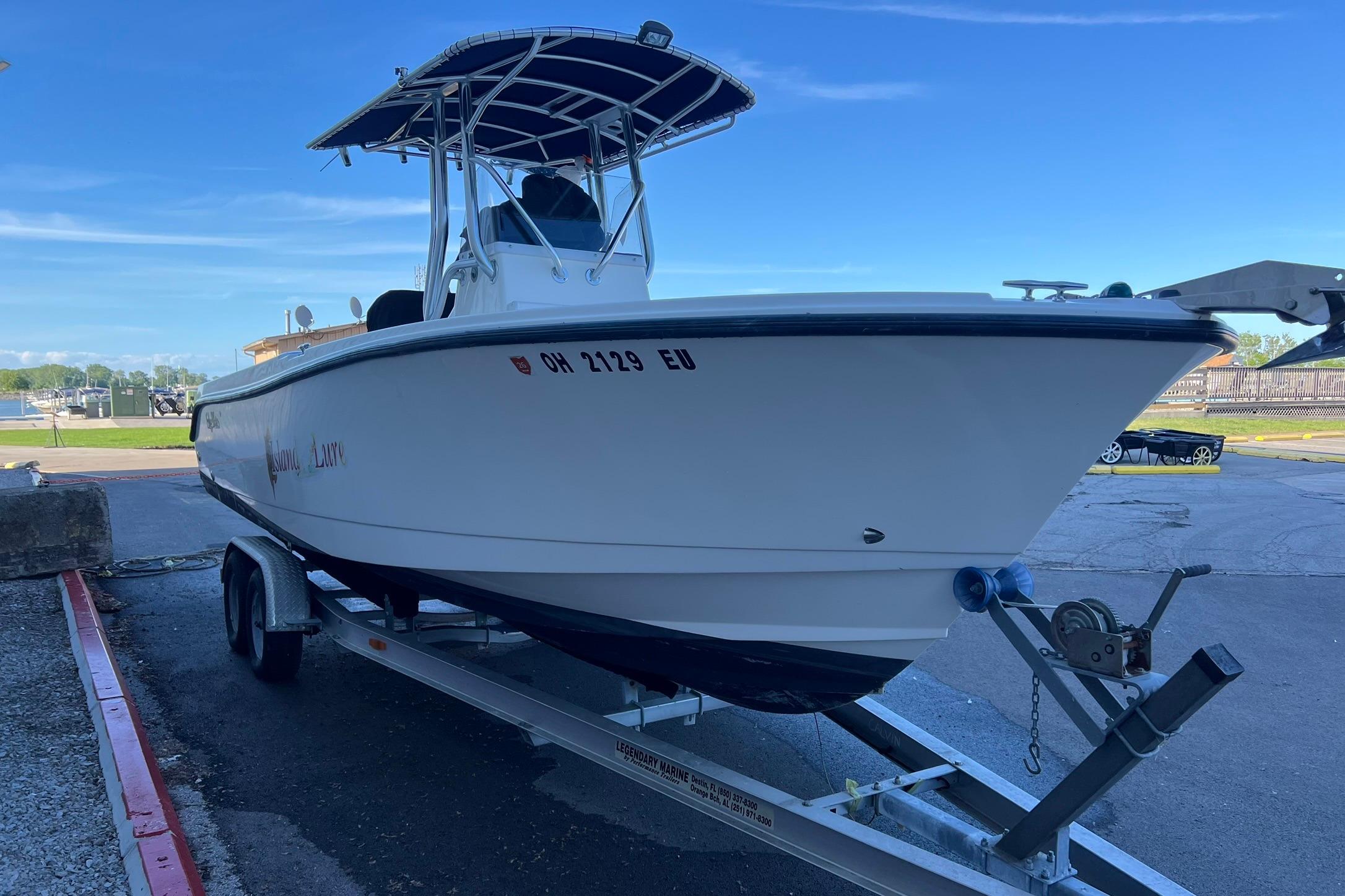 2006 Edgewater 245CC boat on trailer, parked outdoors under clear blue sky.