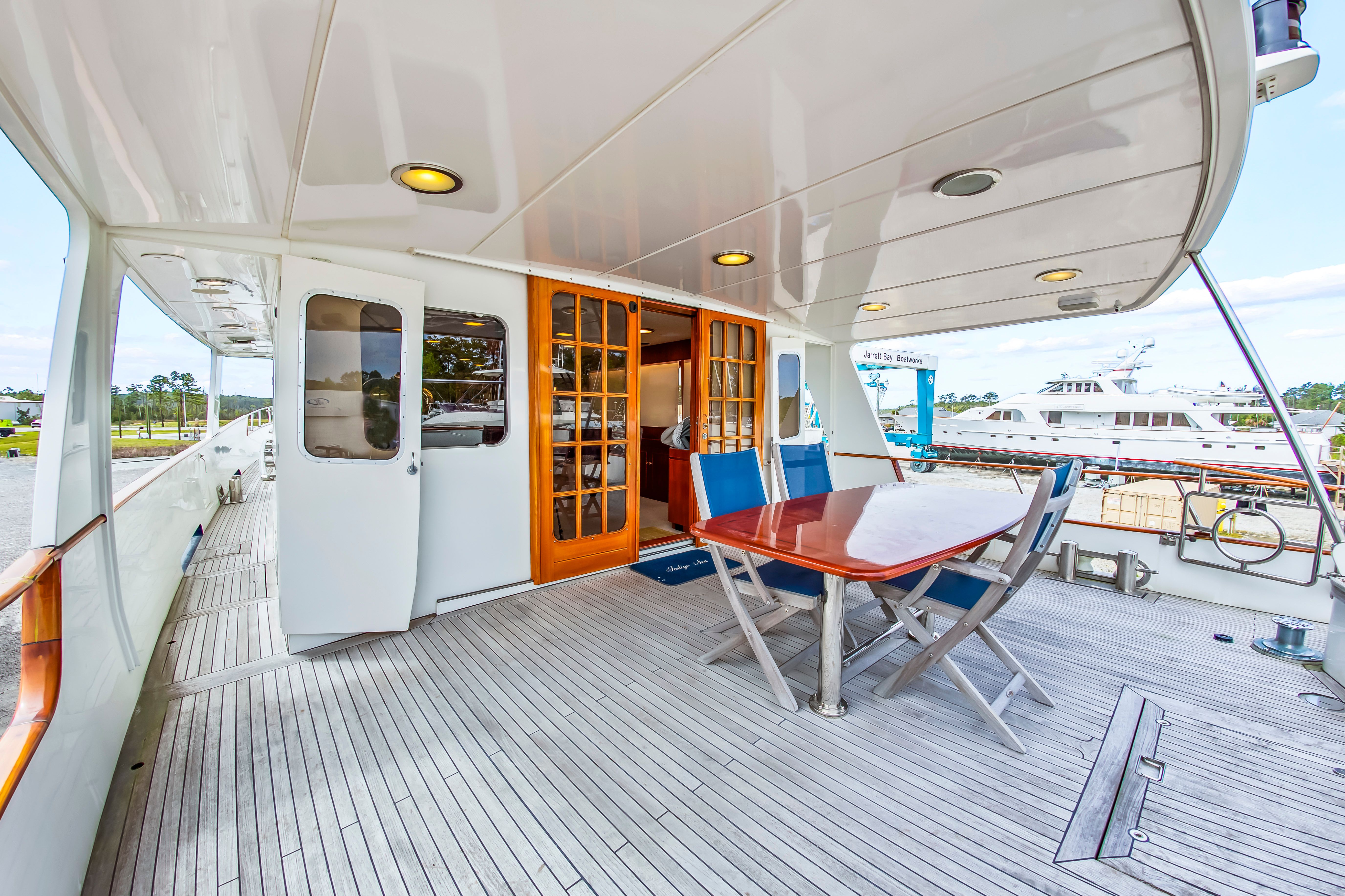 The image shows the deck of a 1987 Jongert 78 Motor Yacht with a table and chairs.