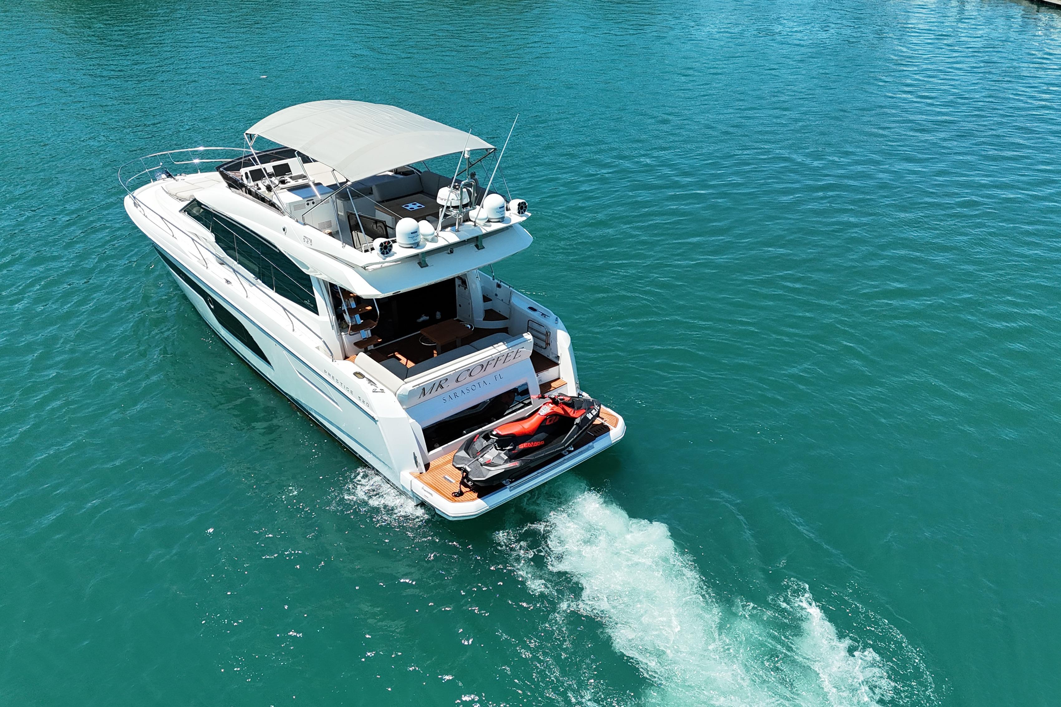 Luxury 2022 Prestige 520 yacht cruising on clear blue water.