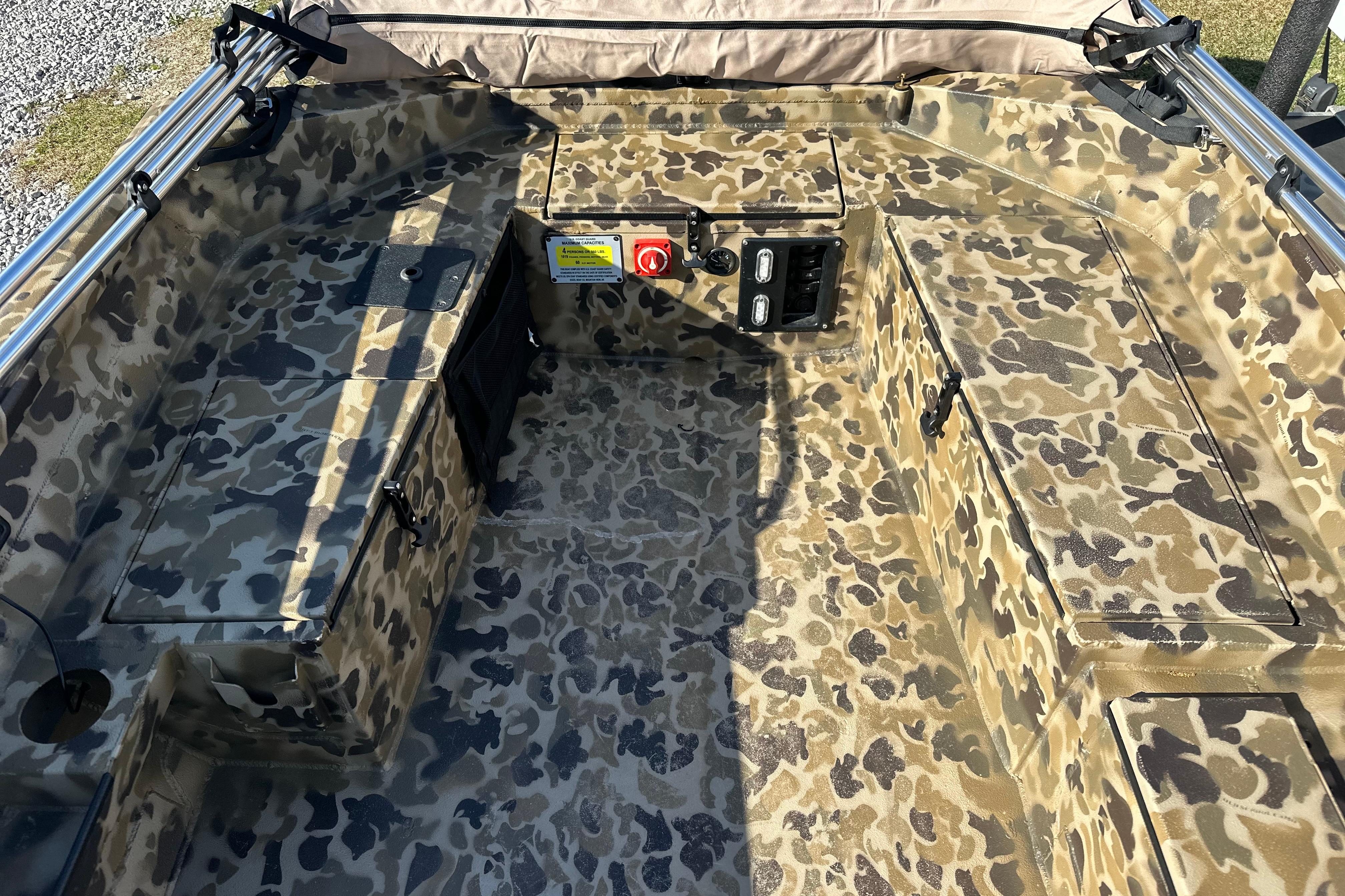 Camouflage interior of 2026 Excel 1751 Viper F4 boat, featuring storage compartments and control panel.