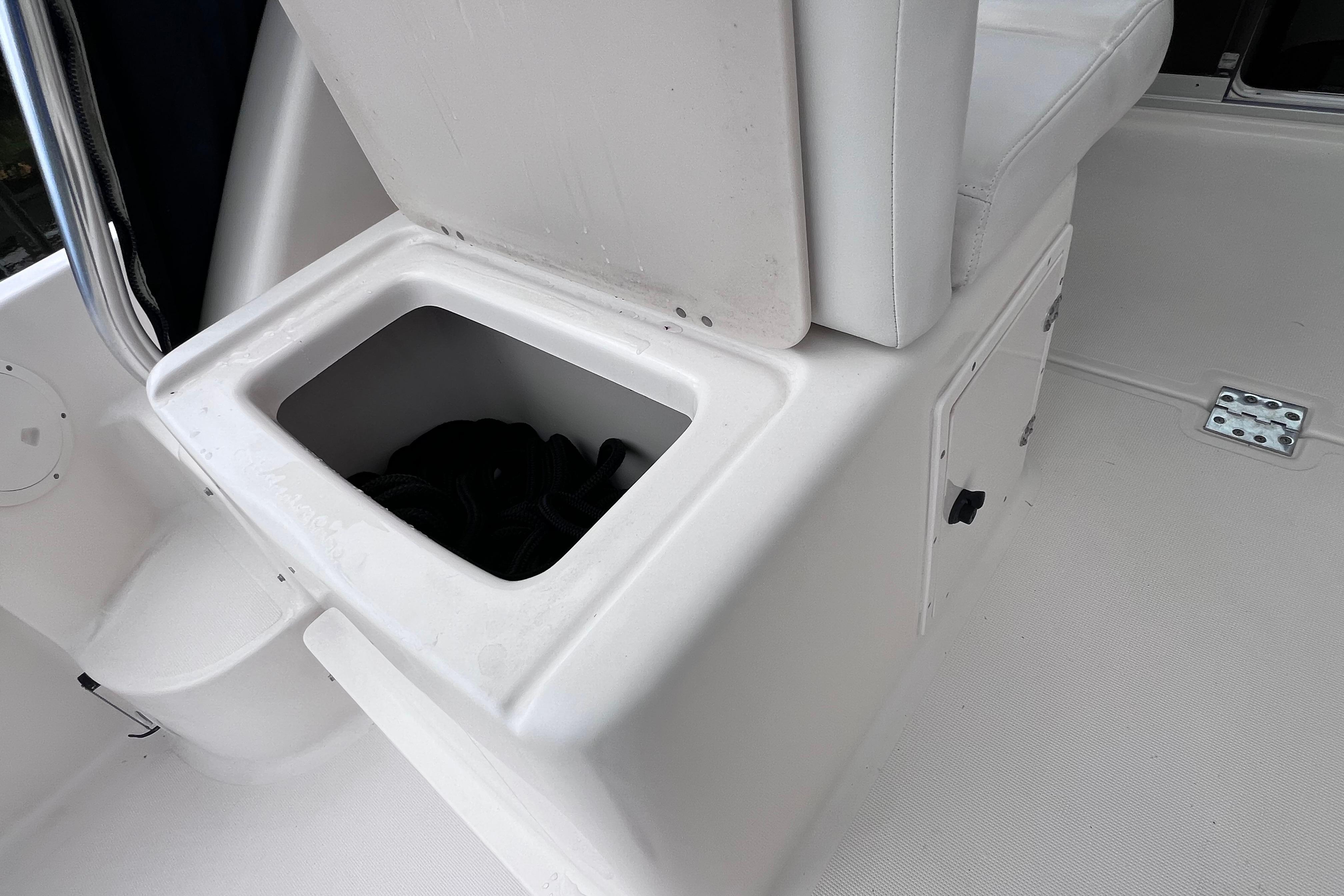 Storage compartment on a 2005 Pursuit 3070 Offshore boat, featuring a cushioned seat.