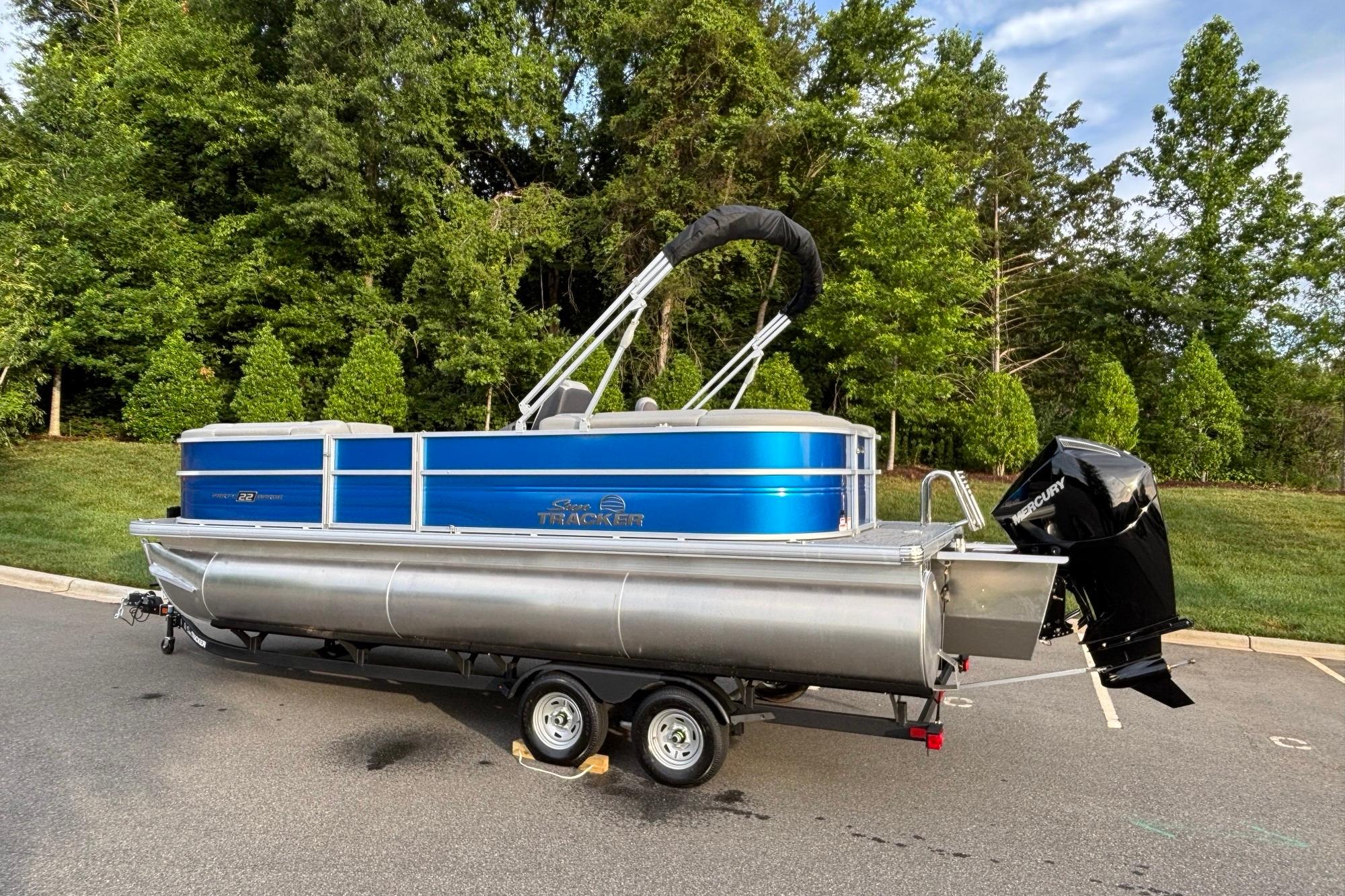 2026 Sun Tracker Party Barge 22 XP3 pontoon boat on trailer, parked outdoors.