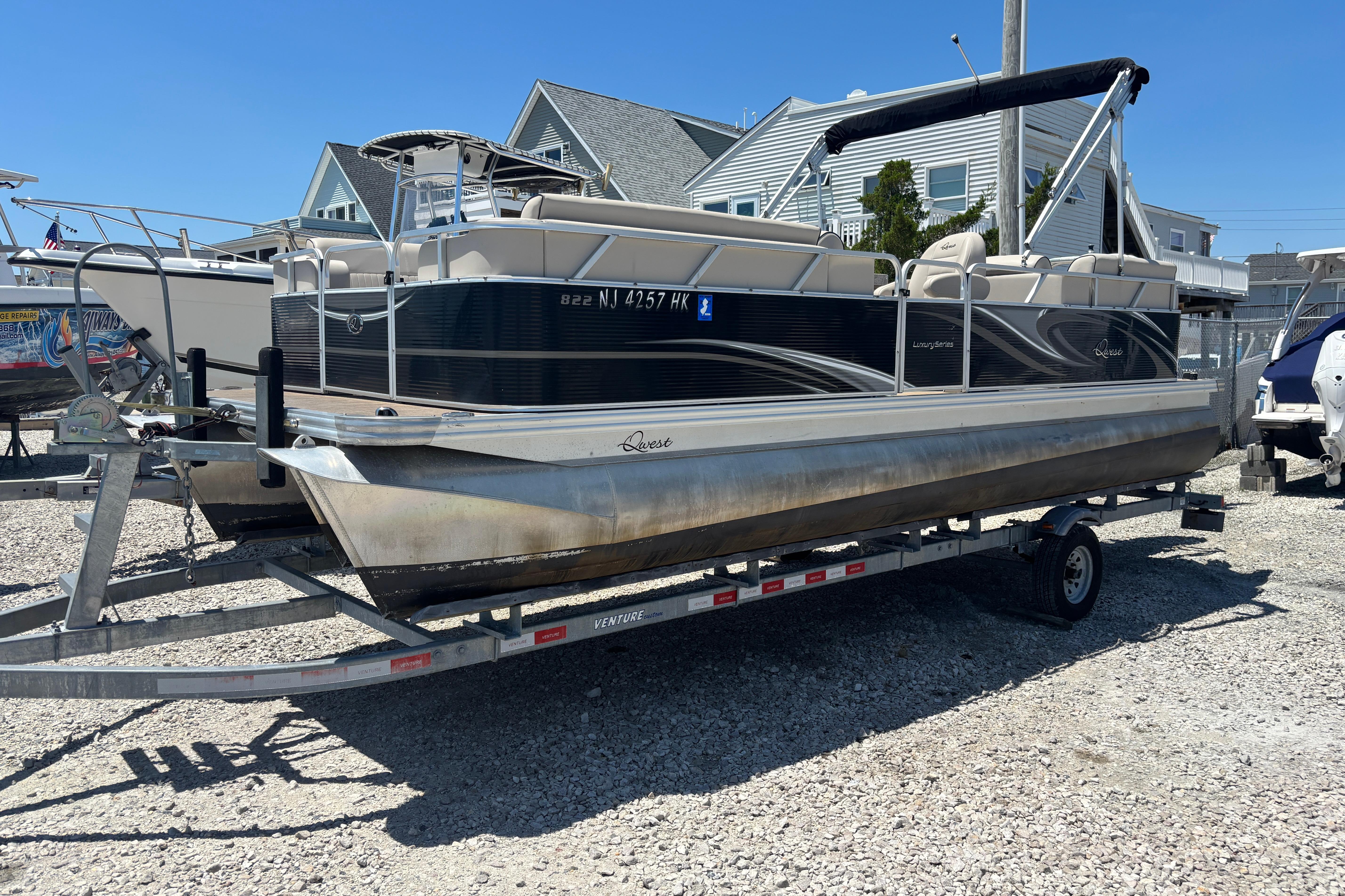 2017 Qwest LS 822 Bar pontoon boat on trailer, parked outdoors.